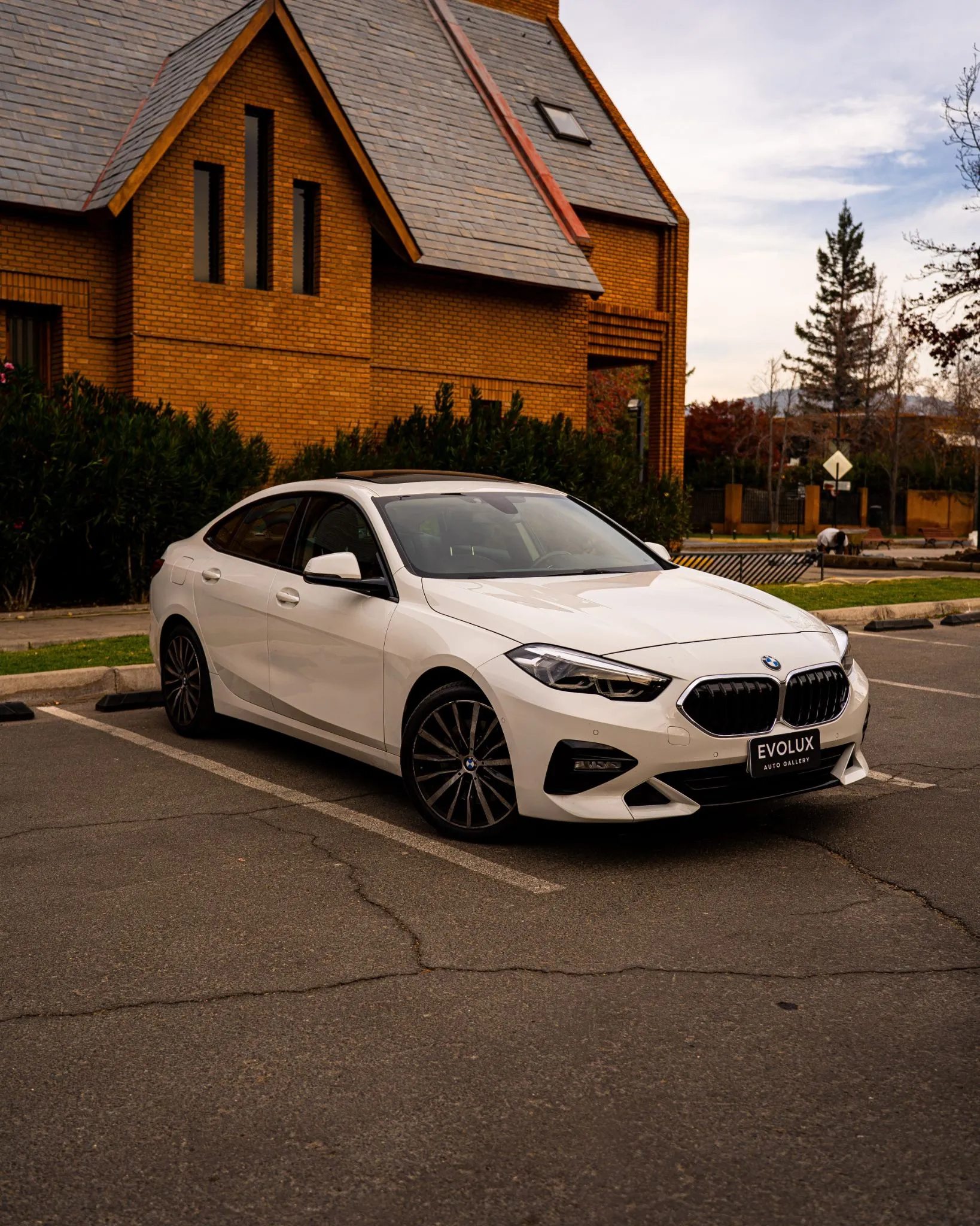 BMW 220d Gran Coupé blanco estacionado frente a edificio de ladrillo, vista frontal tres cuartos
