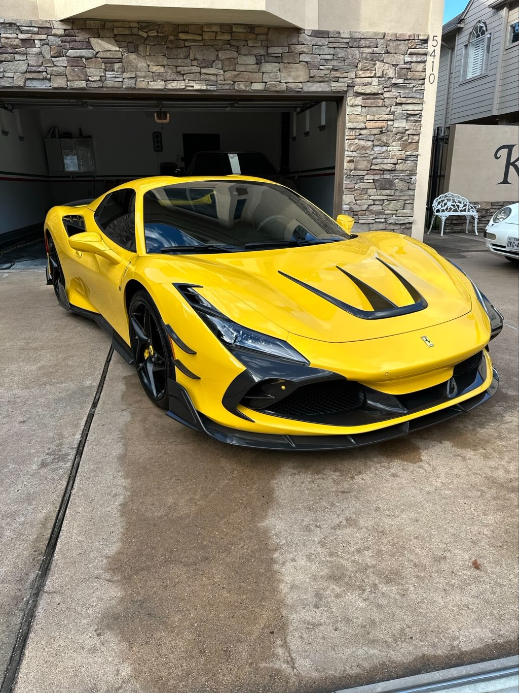 Detailed cleaning of Porsche Panamera wheels using specialized brushes during a mobile car wash in Houston.