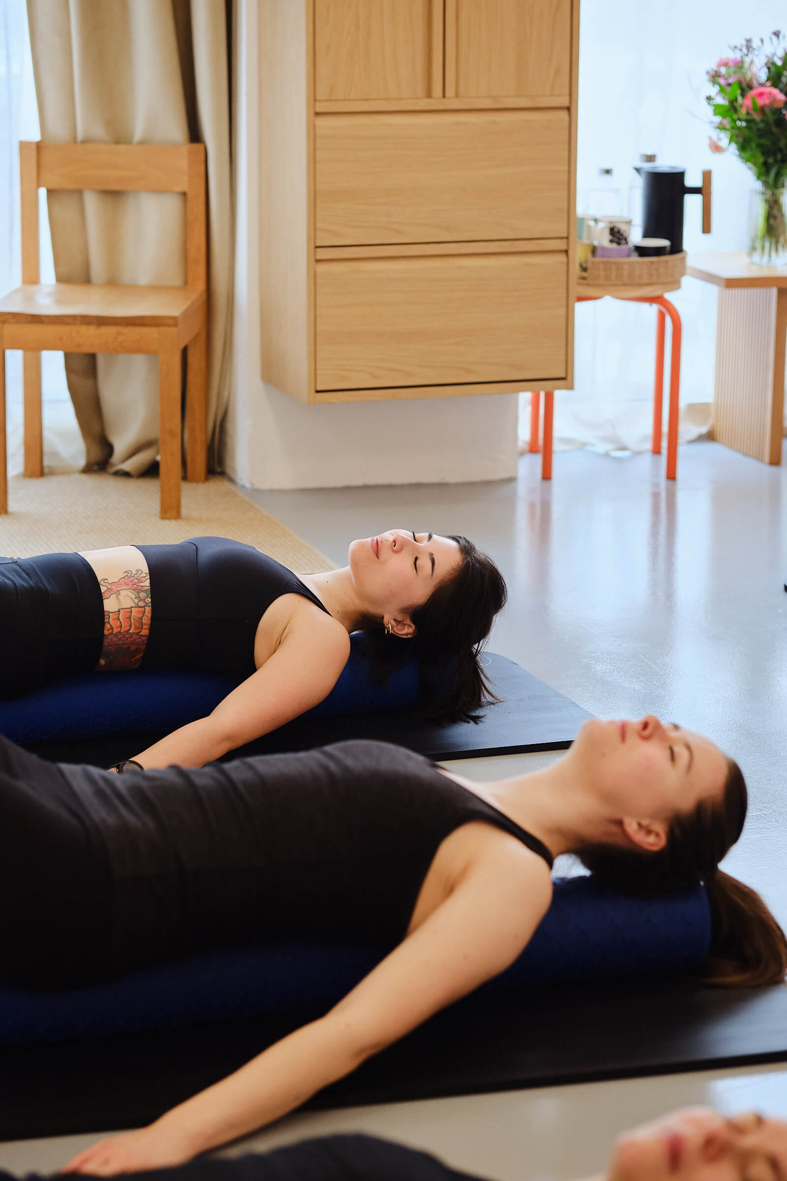 Two women relaxing on a Melt foam roller