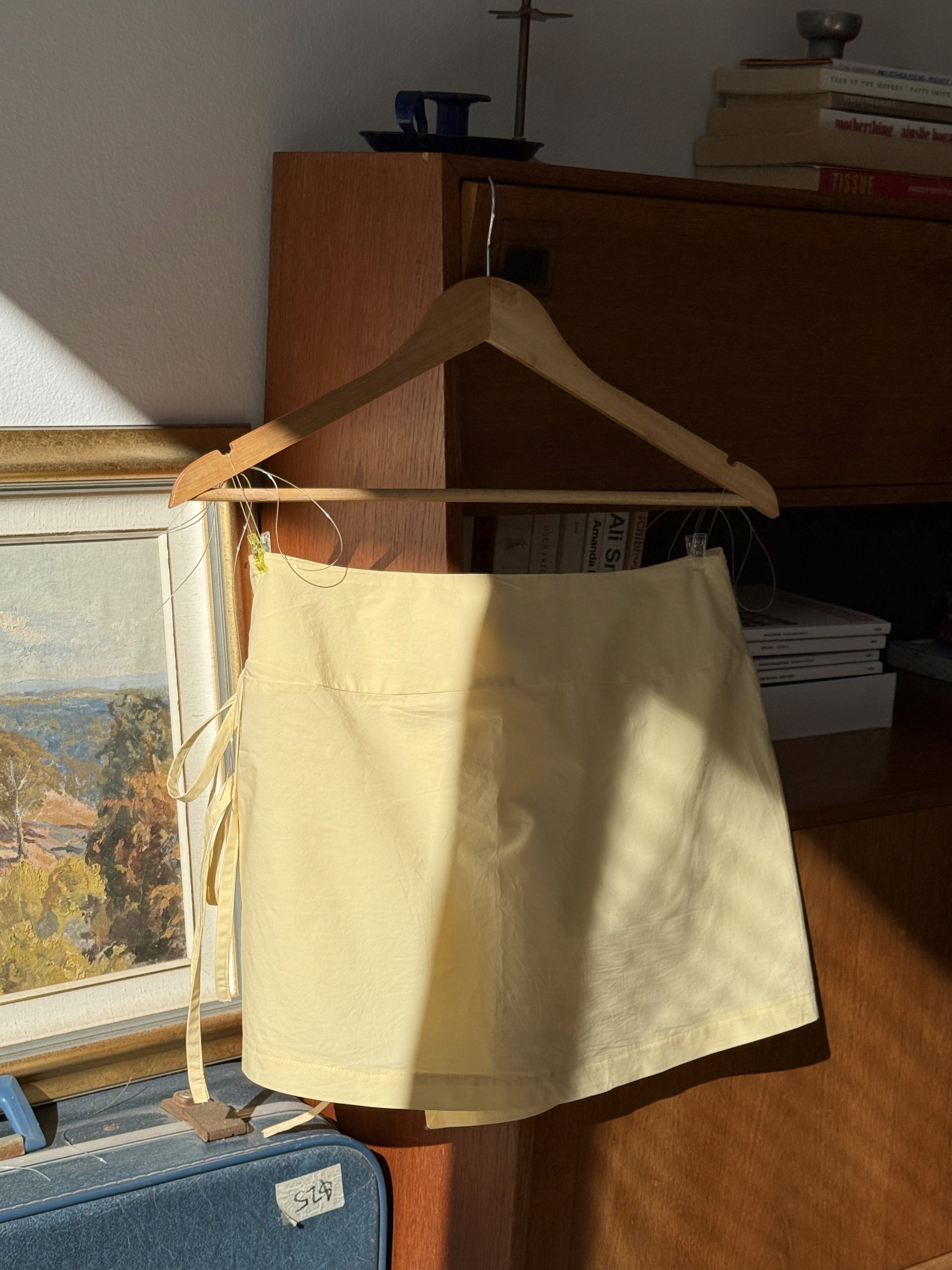 back view of a short yellow wrap skirt