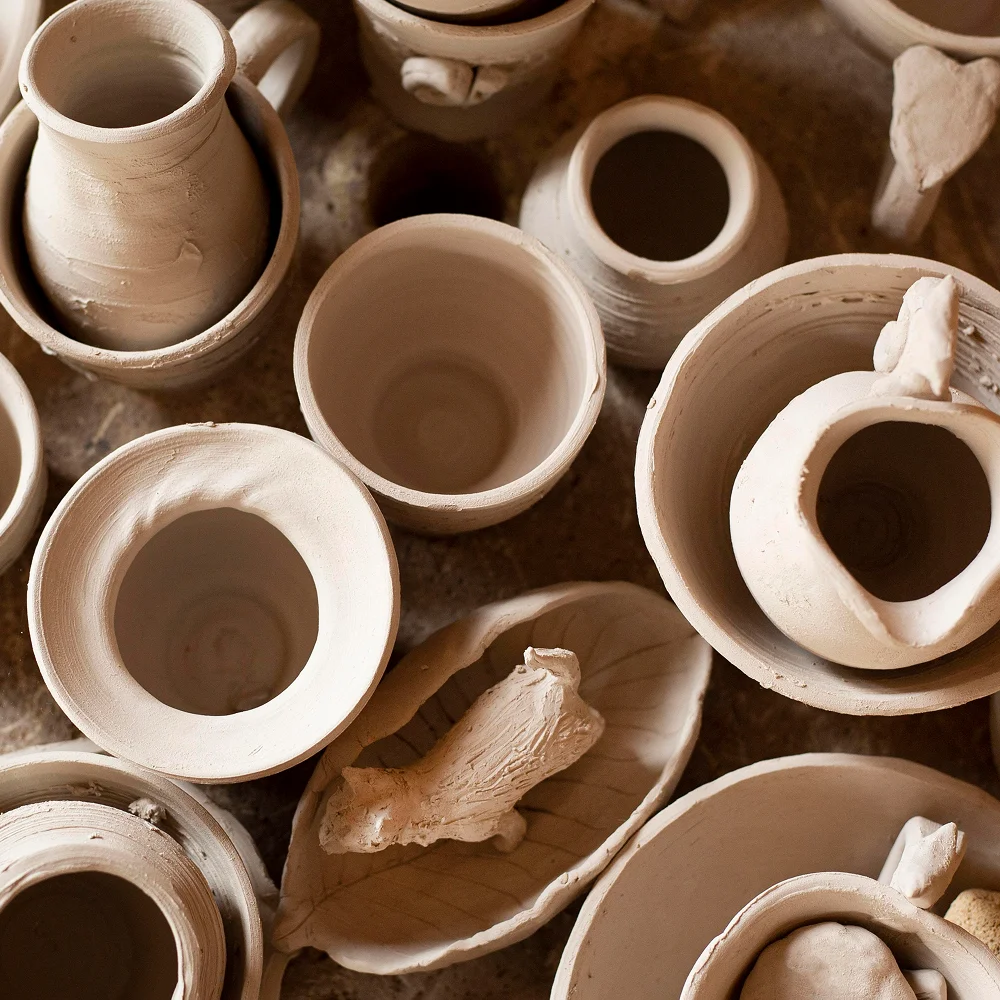 Piezas de barro sin esmaltar en proceso de creación dentro de un taller de cerámica.