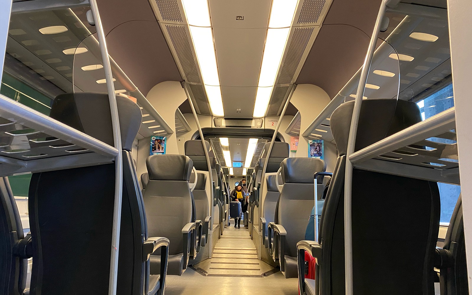 Innanríkissýn af Malpensa Express lestinni með auðum sætum og farangursgeymslum fyrir ofan.