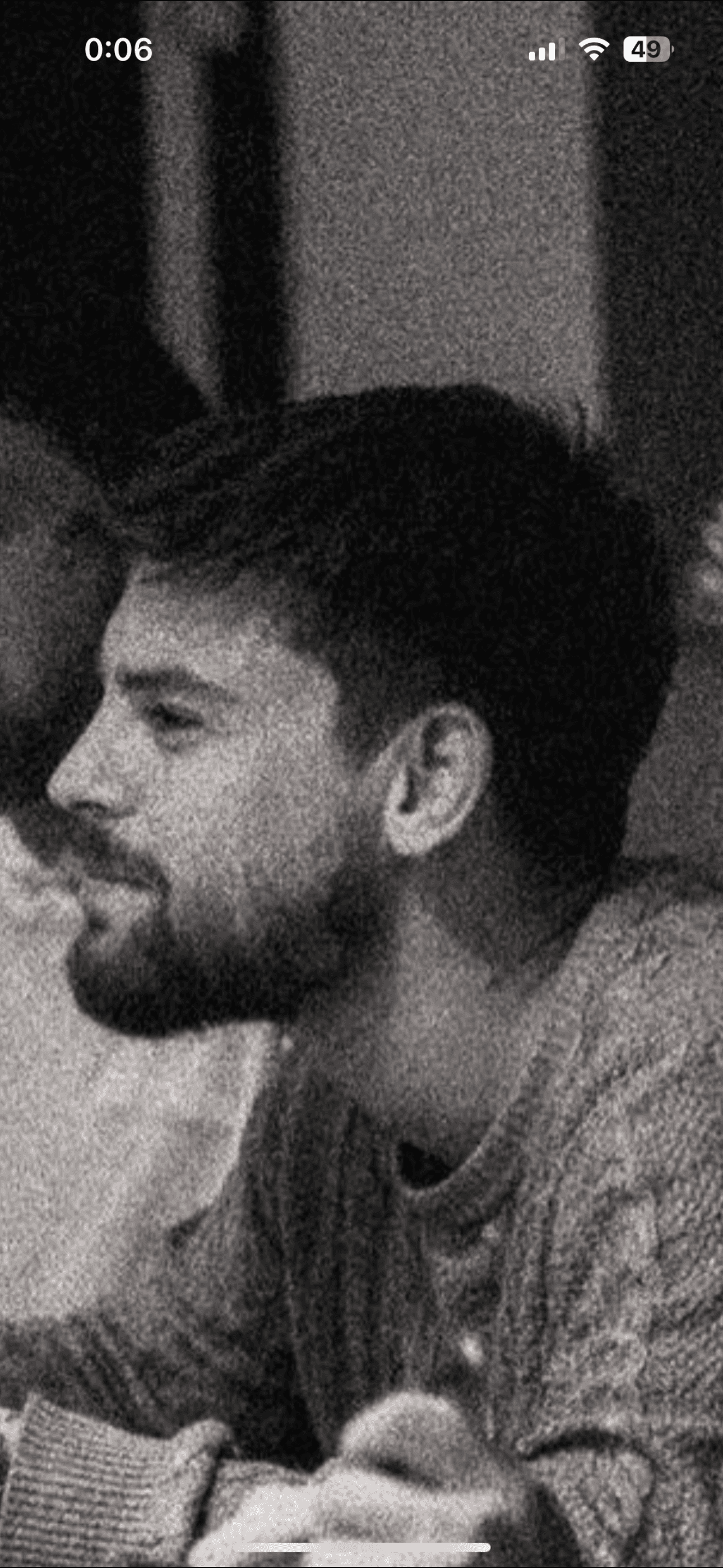 A woman observes framed black-and-white photographs in warm golden light