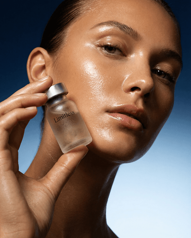 woman in white vest and black bikini with hand on chest