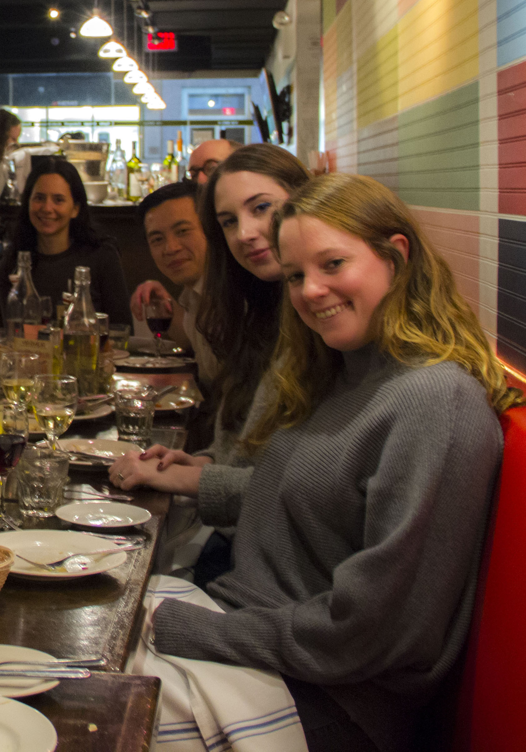A photo of a group of people siting at a table in a restaurant.