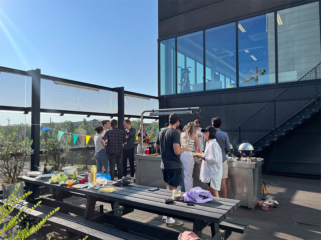 Mensen verzamelden zich op een dakterras rond een buitentafel