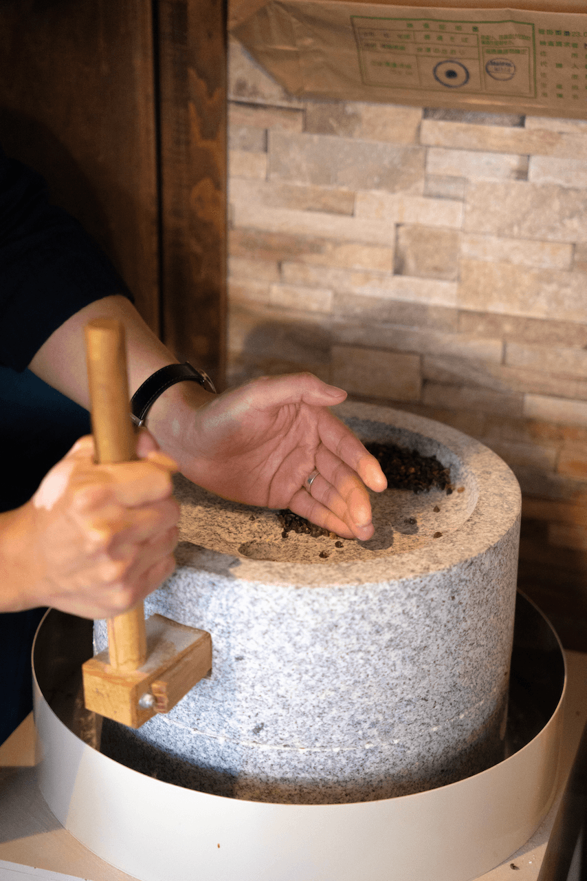 Pouring flour grains into stone mill for milling