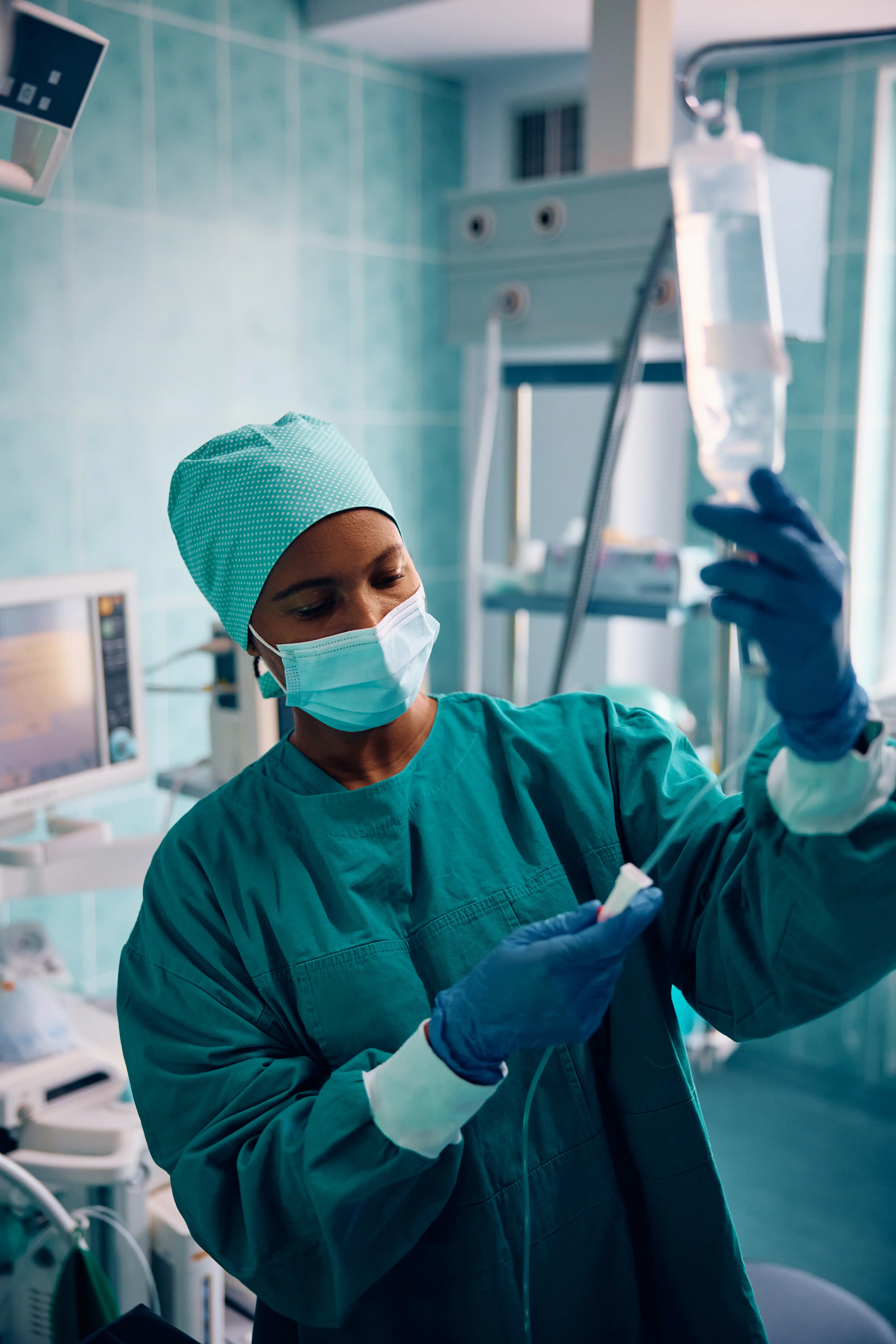 Hospital nurse preparing an IV bag, representing nurse missed breaks and meal waiver claims under California Wage Order No. 5