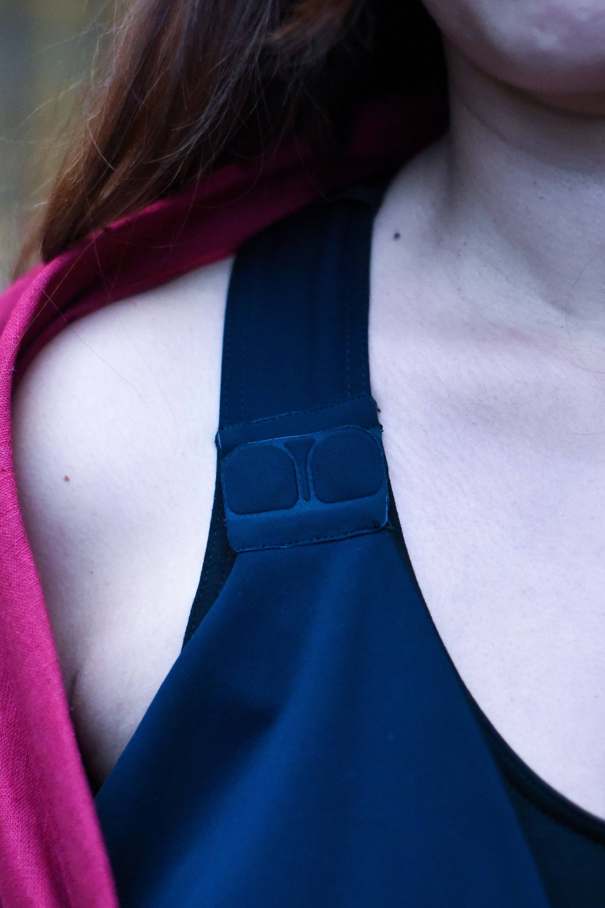 Gros plan sur les pads d’attache intégrés à la brassière sous le chemisier d’allaitement, montrant la technologie discrète qui facilite l’ouverture et l’accessibilité pour l’allaitement.