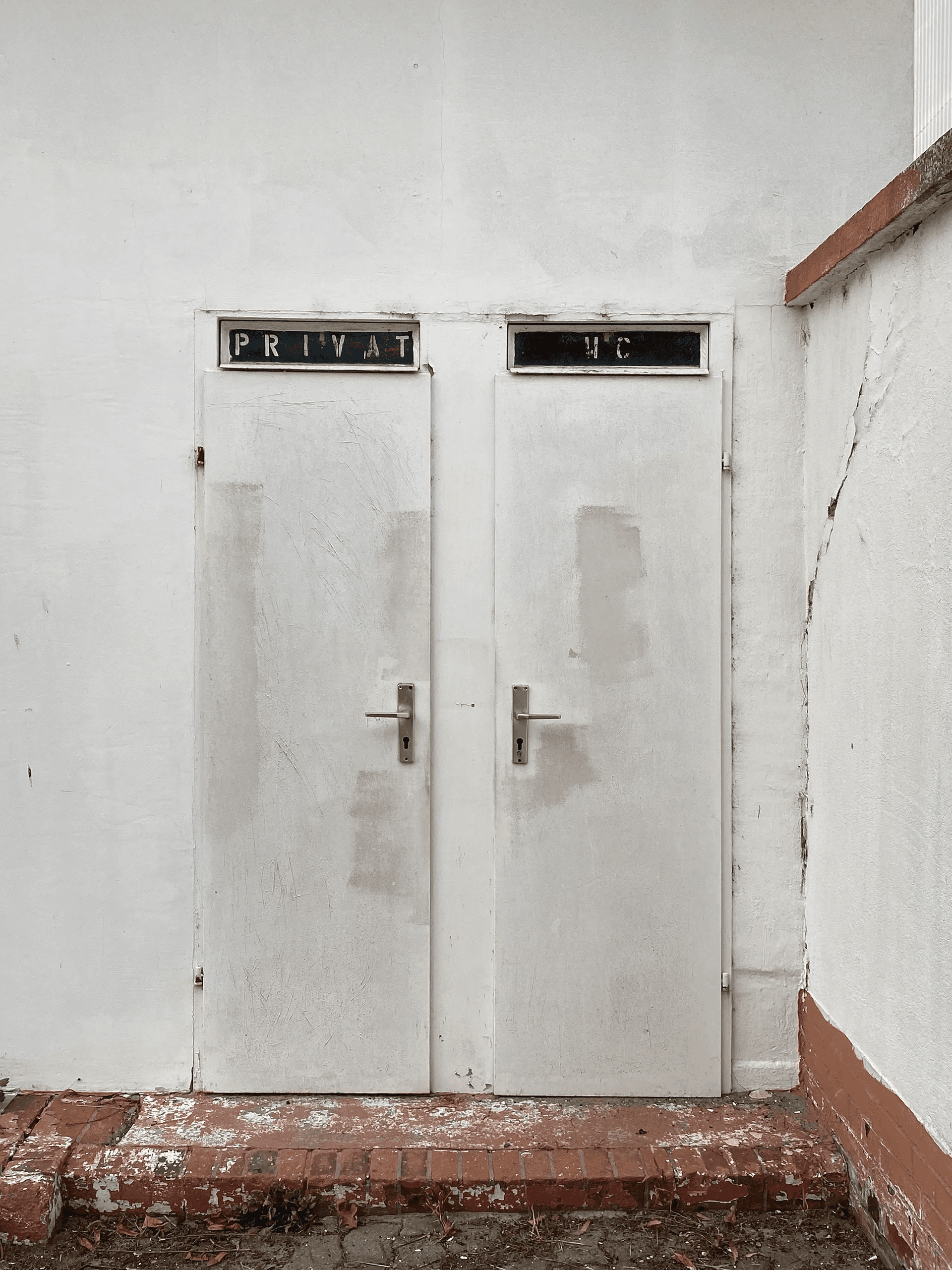 Seitliche Zugänge ‚Privat‘ und ‚WC‘ am Tankstelle-Kyritz-Ensemble mit differenzierten Fassadenöffnungen