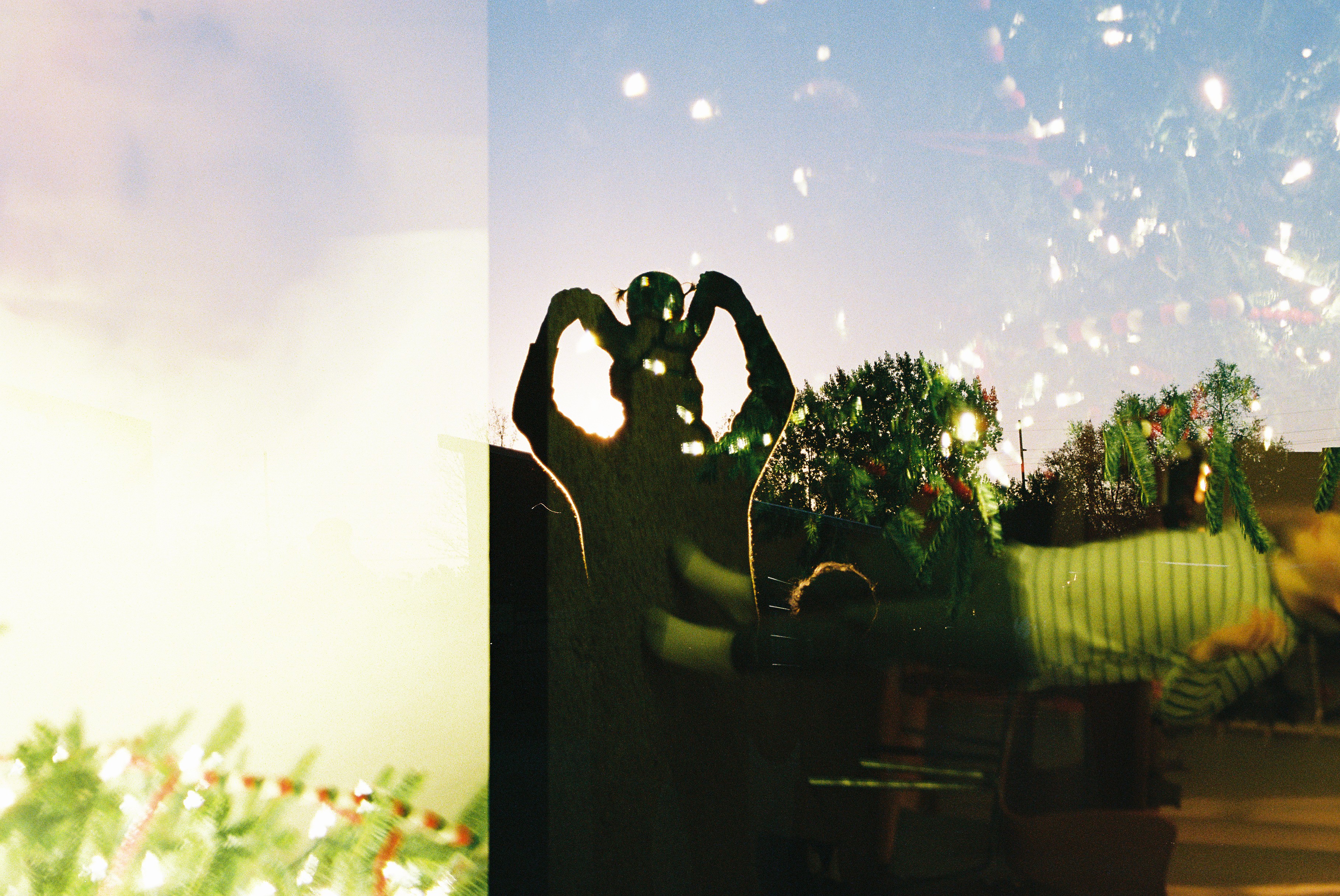 Double exposed image of dad plus kids sillouhette and christmas lights