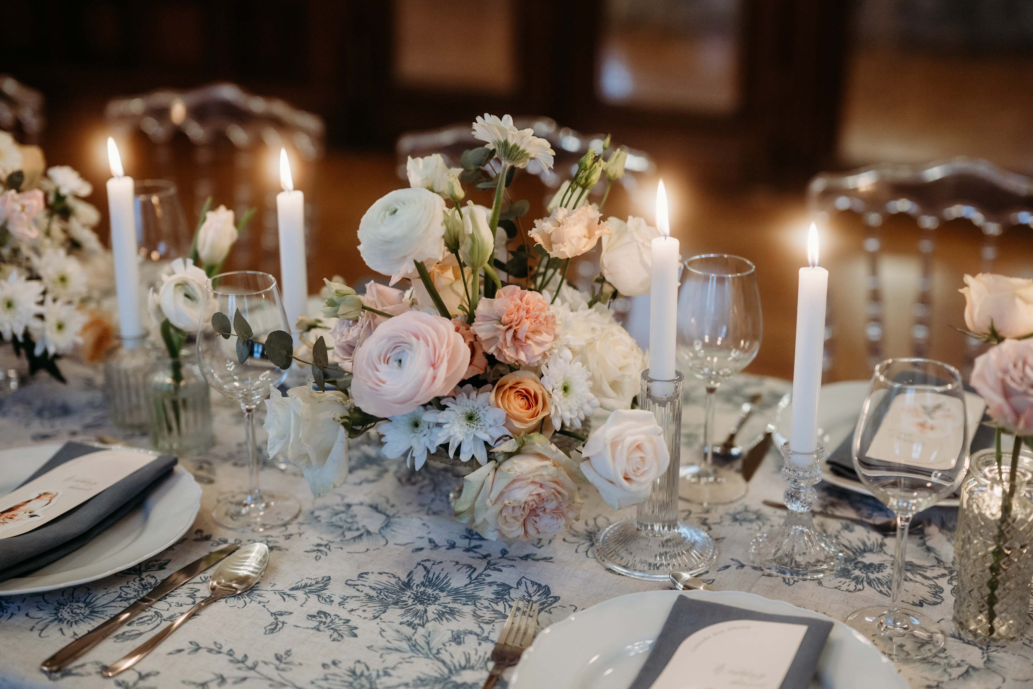 Tischdekoration in pfirsich- und himmelblauen Farben mit Kerzenschein.