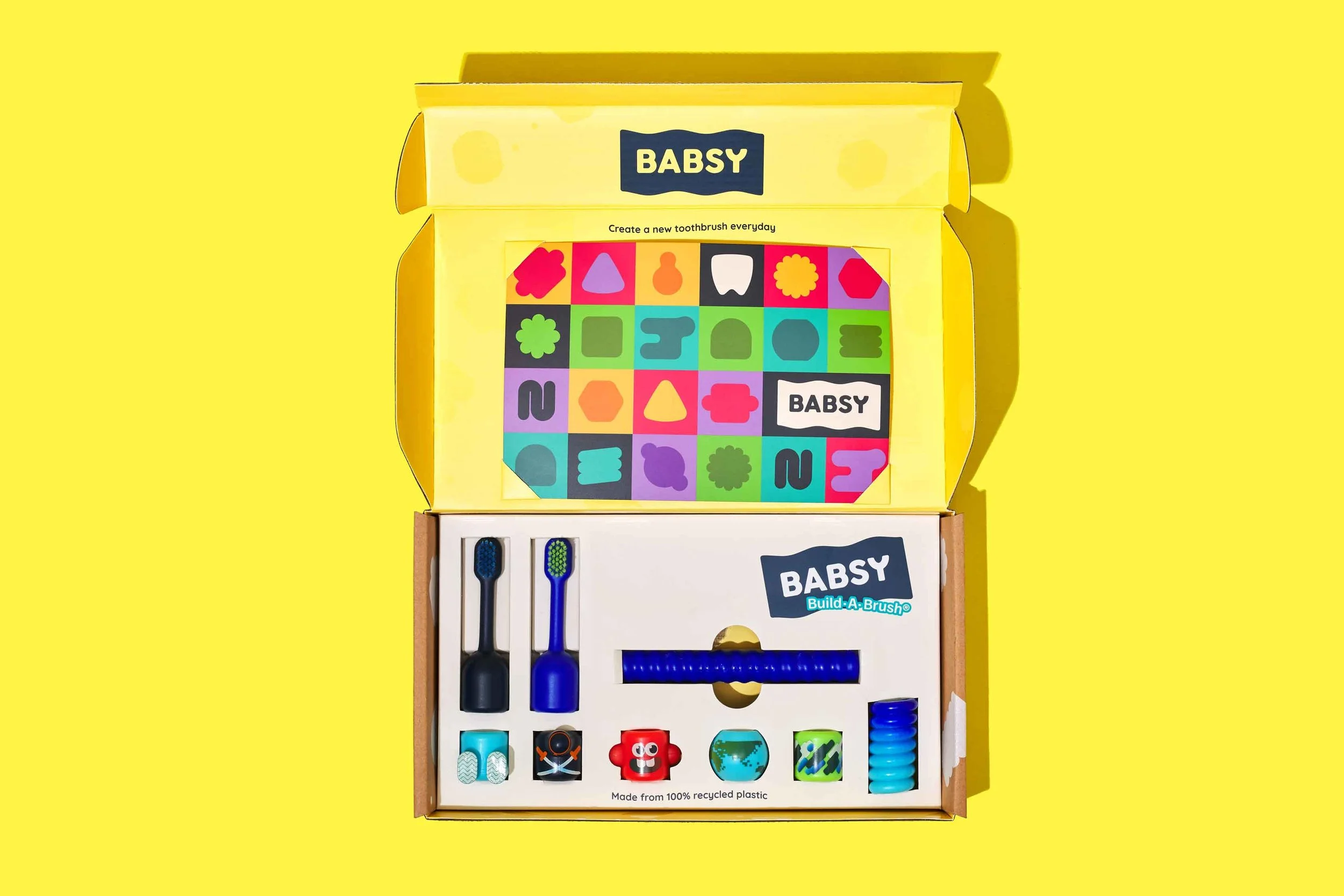 Open BABSY Build-A-Brush kit with toothbrush components, character pieces, and activity cards