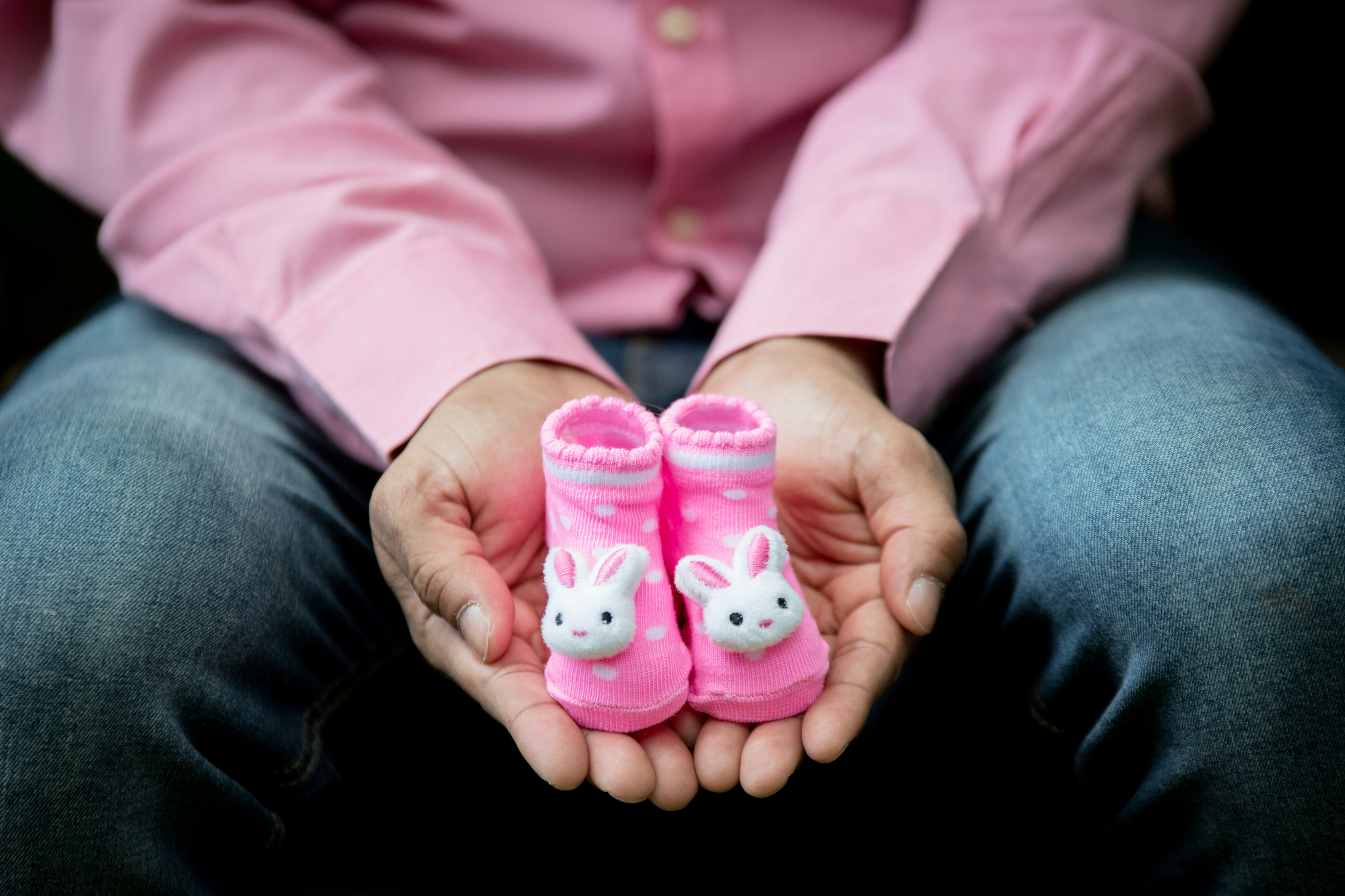 person holding pink and white hello kitty plastic toy