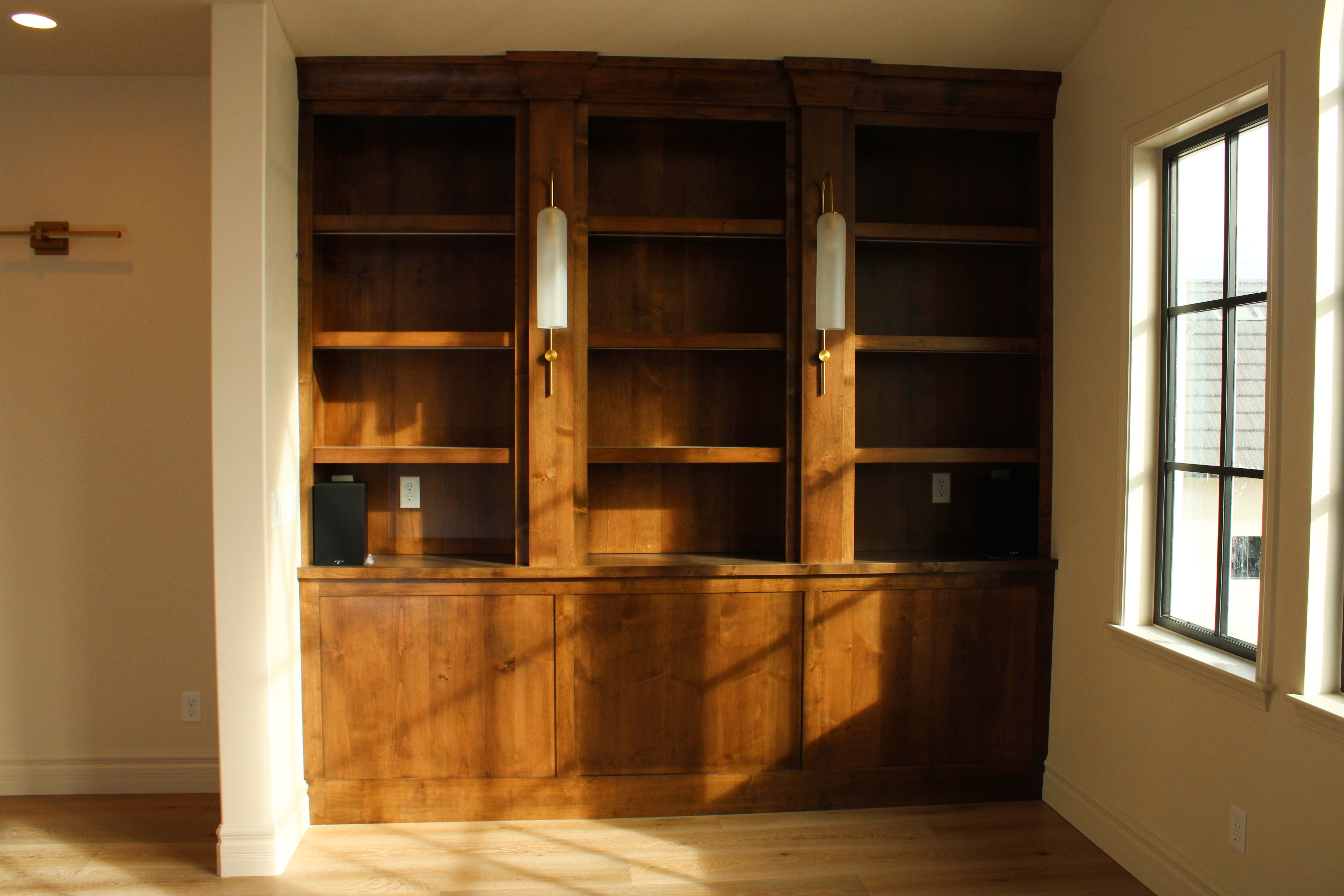 Library space in a St. George, Utah custom home with custom cabinetry and wall sconces.