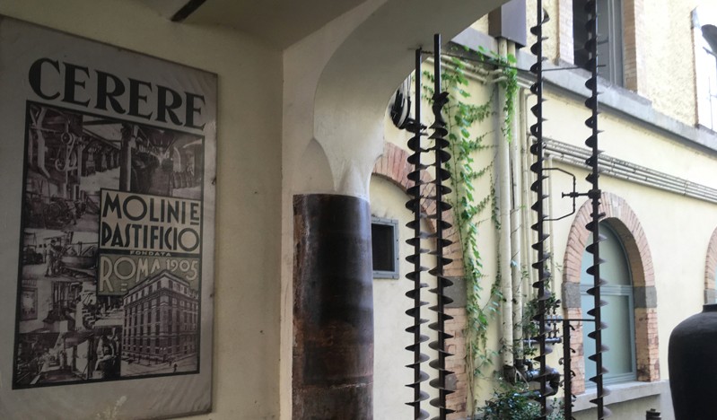 A photo of an old building with a plaque on a wall that has the text CERERE and also some pictures of old roman buildings.