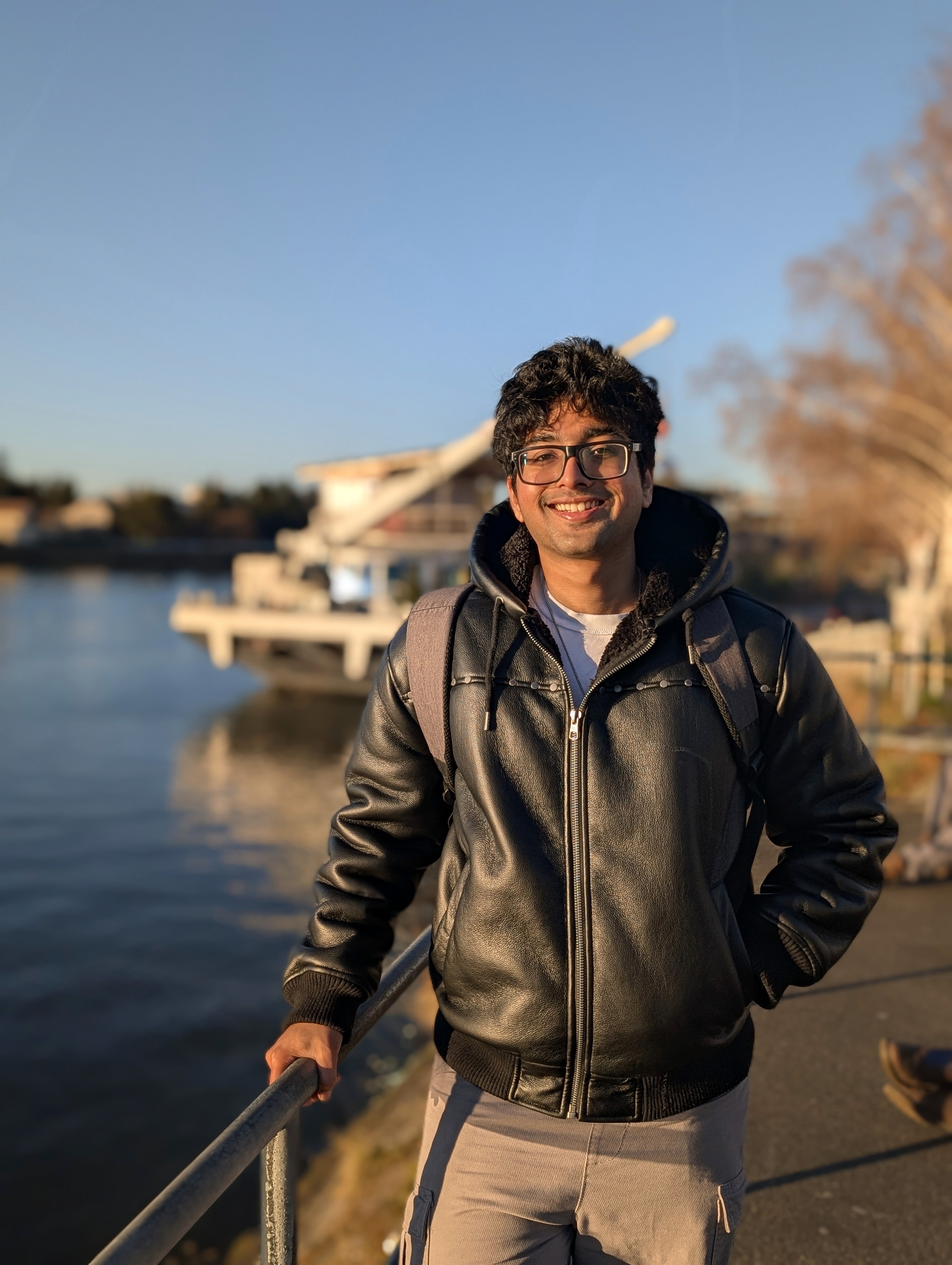 A thoughtful young person with dark hair gazes to the side, captured in soft black and white lighting.