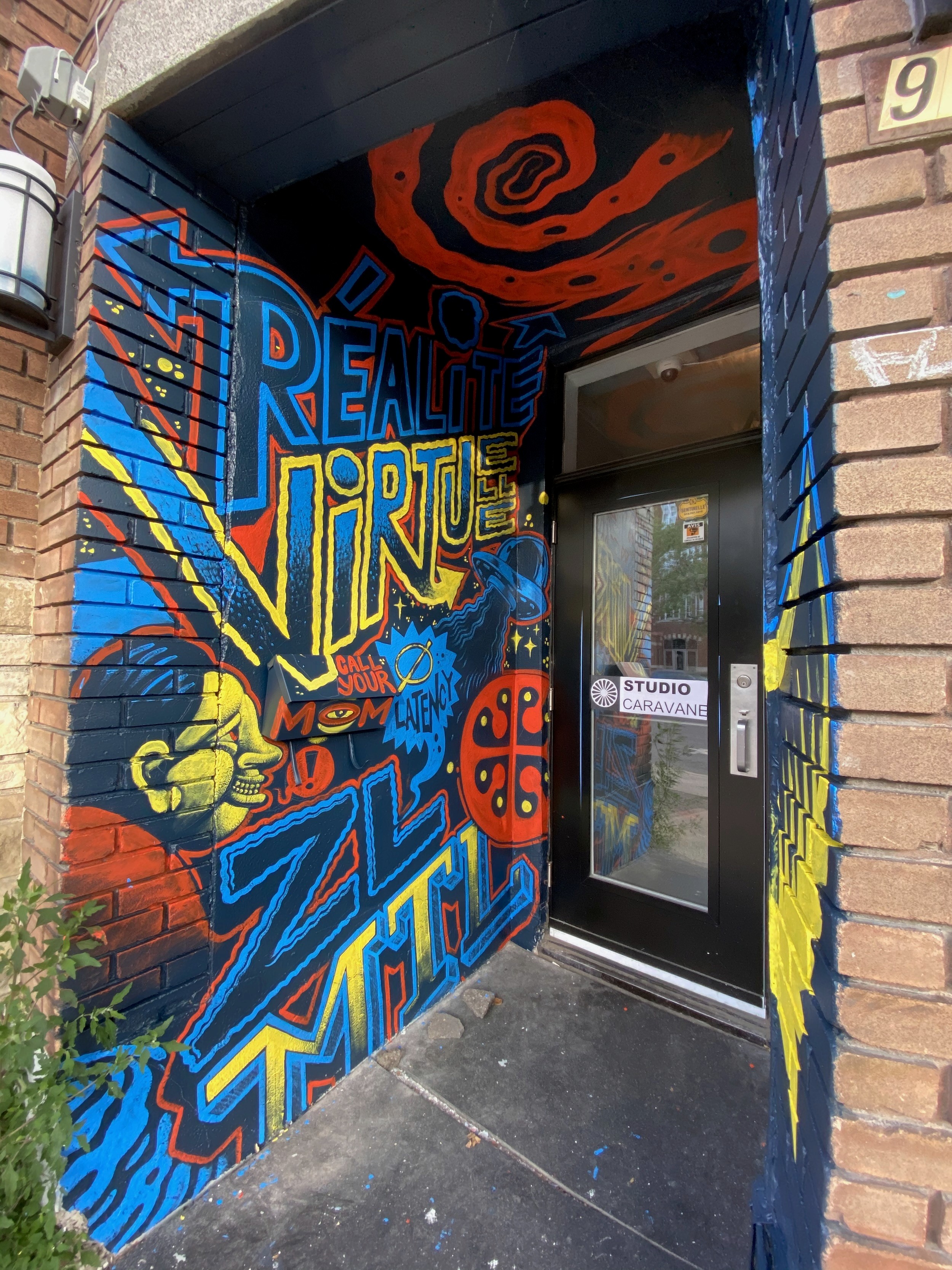 A vestibule's walls and door frame wrapped in bright lettering and red swirls.