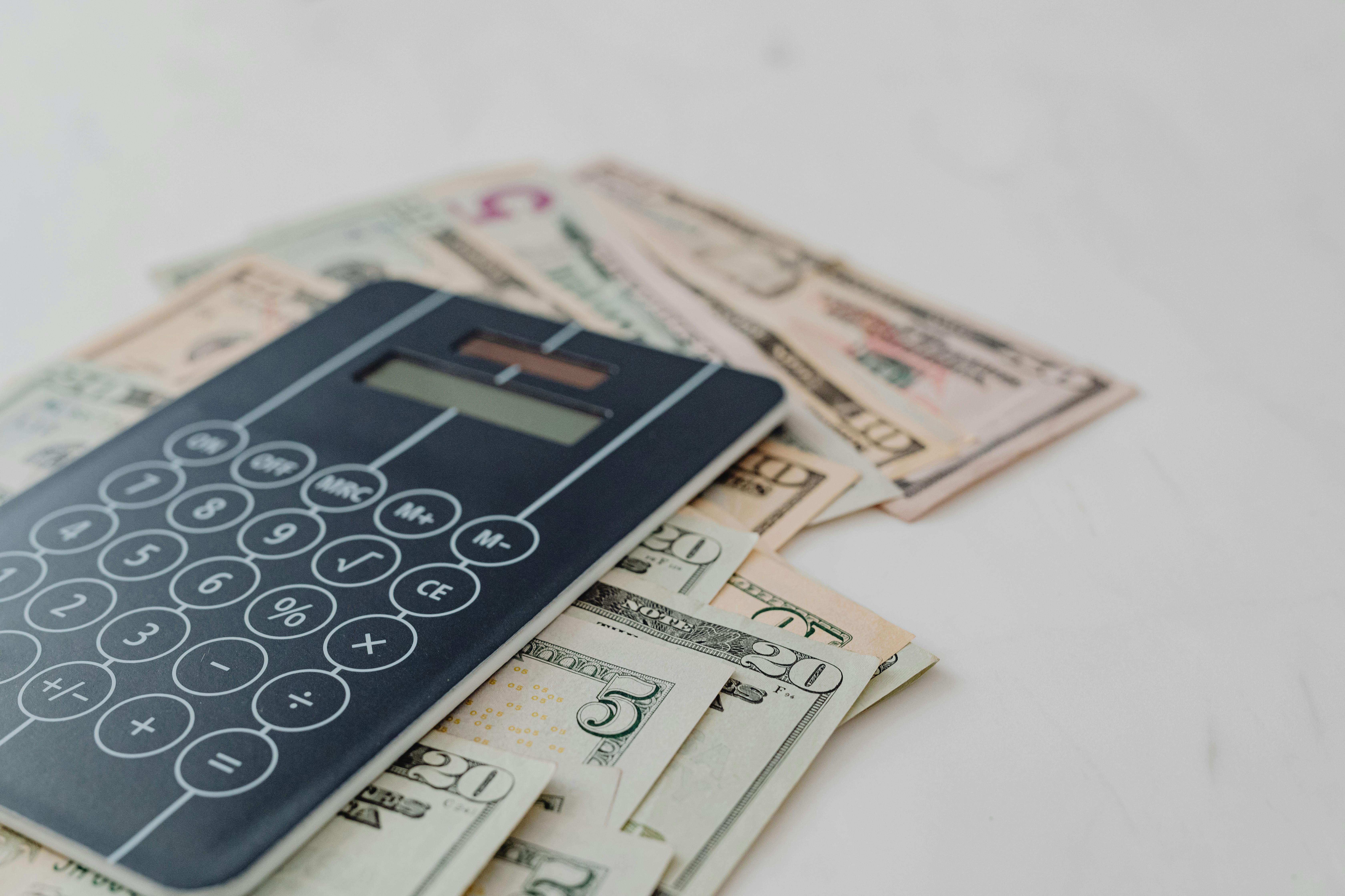 A person is signing some documents and there are stacks of coins on the table.