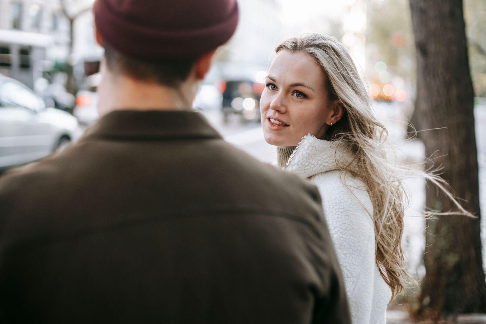 Eine Frau dreht sich beim Spaziergang lächelnd zu ihrem Date um und hält Blickkontakt