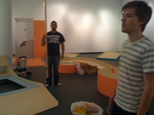 two men working on installation of decorations for an exhibition gallery