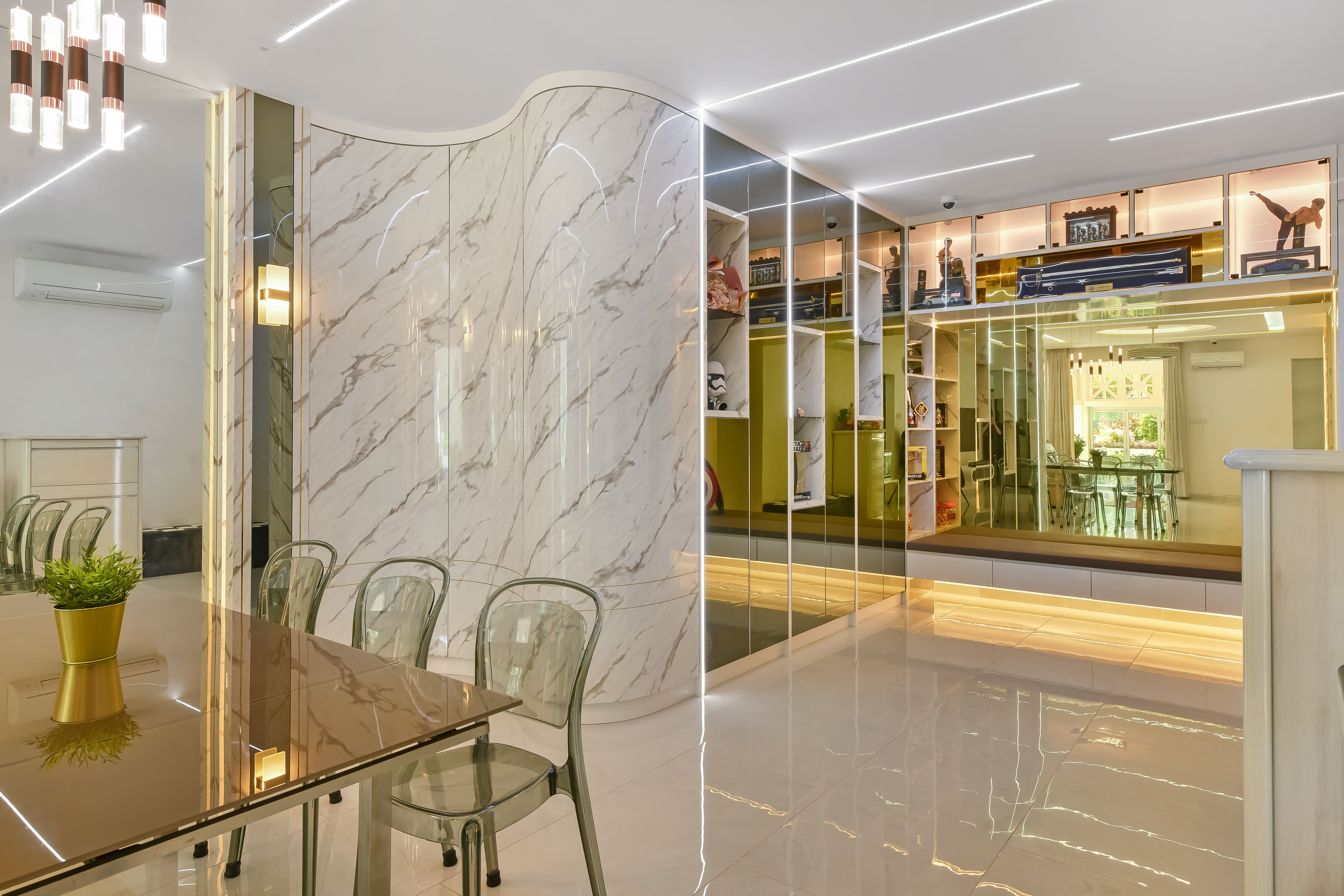 Dining area with marble feature wall and mirrored storage, highlighted by warm lighting and a glass-top dining set that enhances spaciousness.