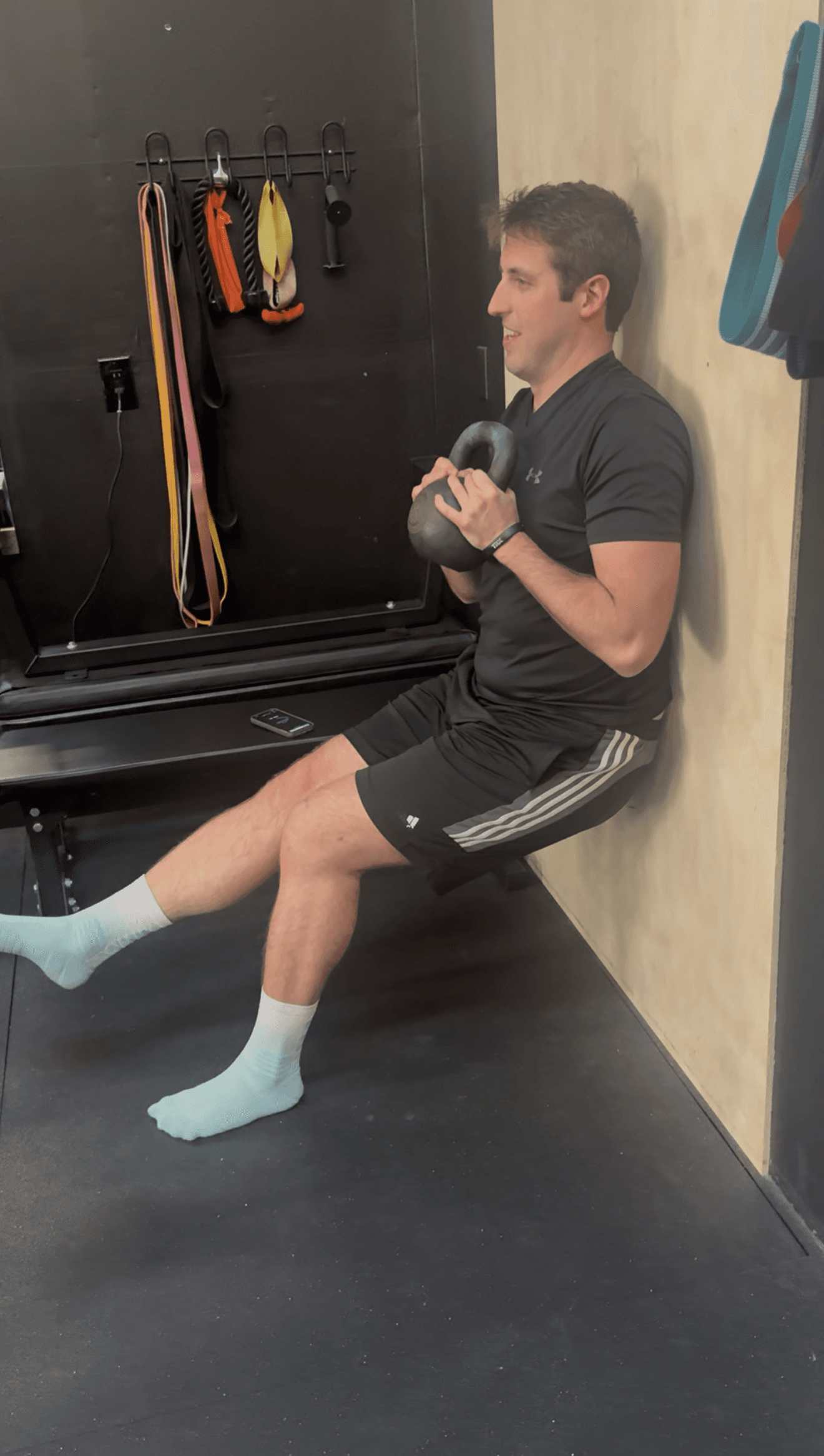 Wall constrained single leg isometric squat by patient in Hillsboro, OR during physical therapy