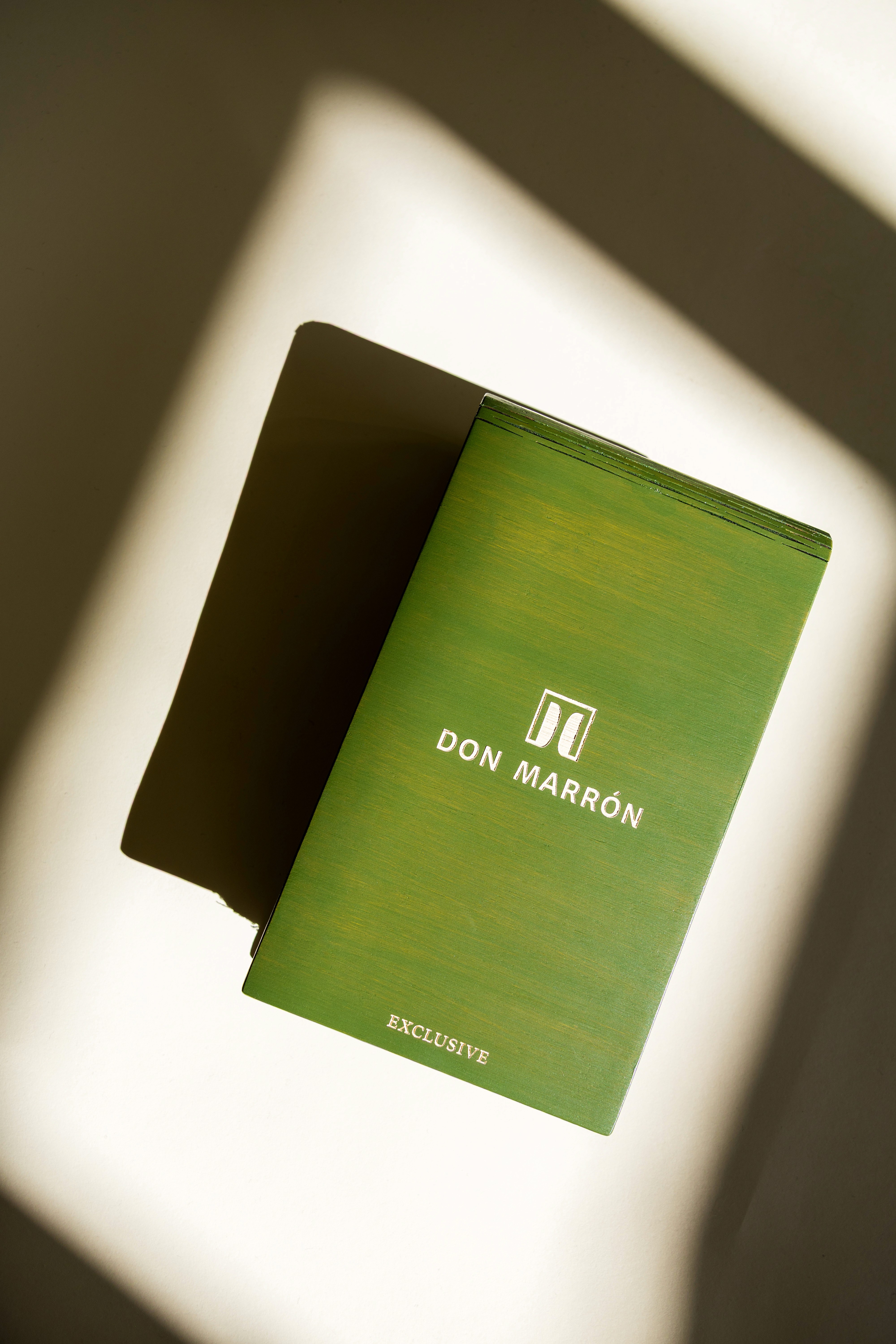 Man in yellow shirt and light blue trousers walking through an Italian market, carrying a luxury garment bag and showcasing effortless summer style.