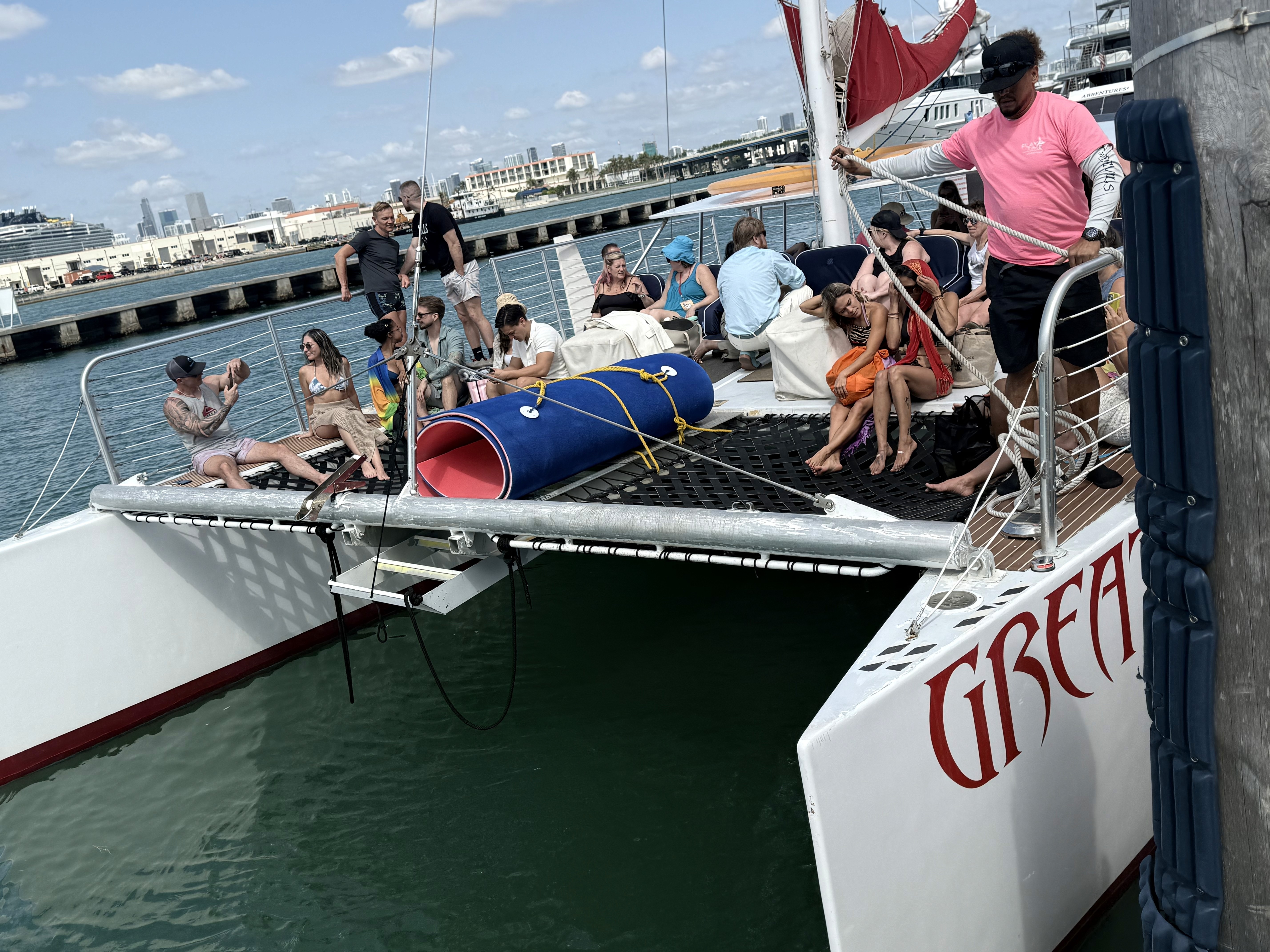 man standing near cliff looking at body of water during daytime