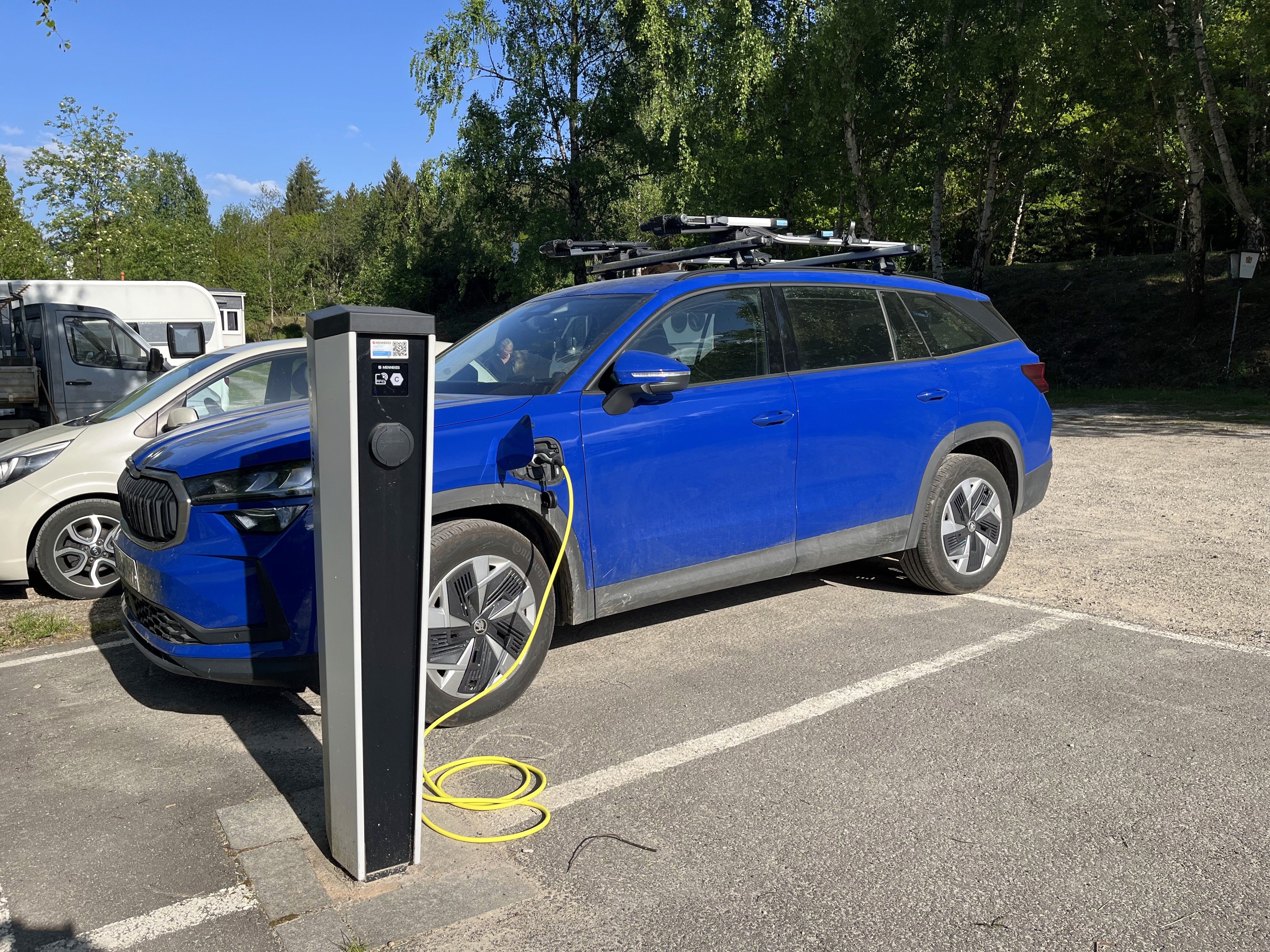 blaues Auto an der E-Ladestation angeschlossen