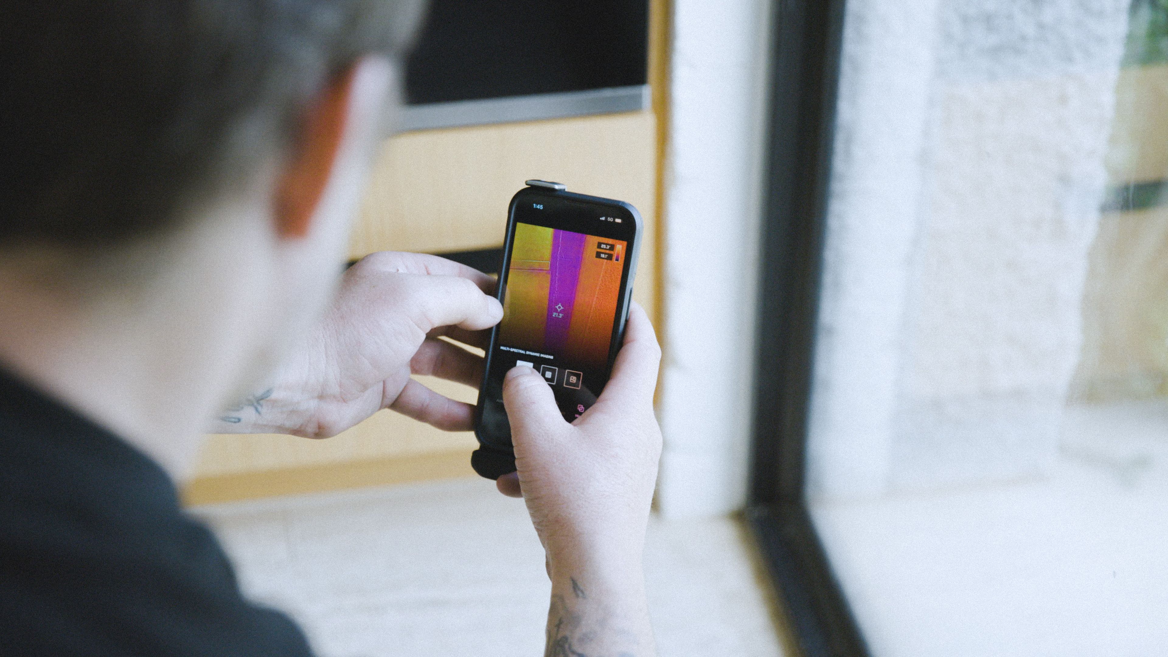 Good Maintenance technician using leak detection app on phone