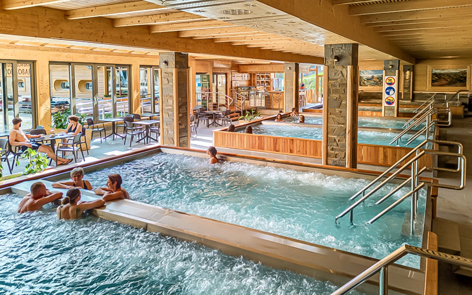 Крытые бассейны в Термальных купальнях Хохолов с людьми, отдыхающими и наслаждающимися водой.