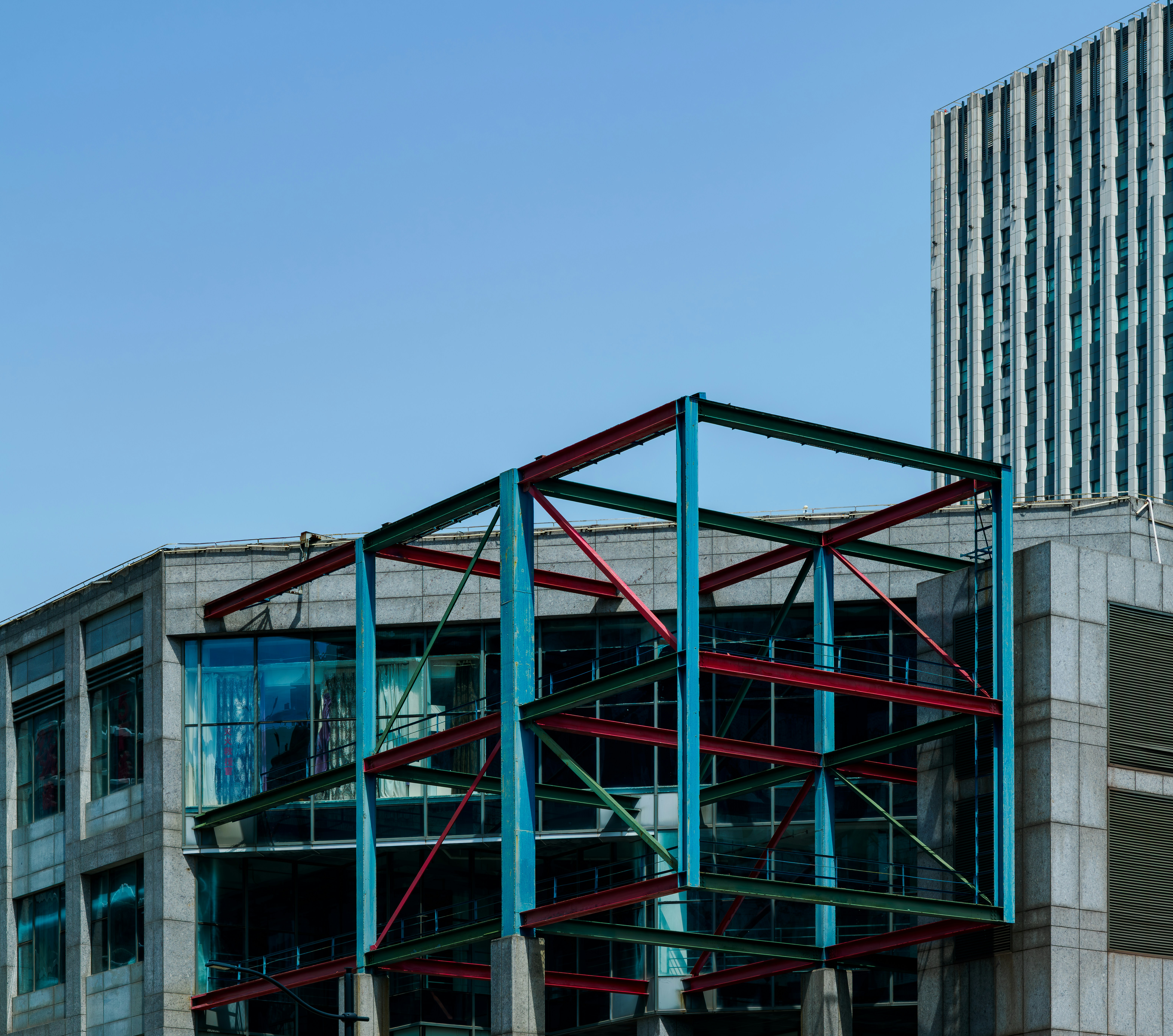 Modern building under construction with colorful steel frame.