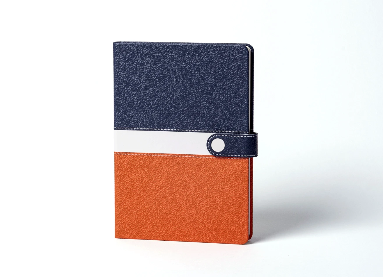 Front view of standing blue and orange color-block notebook.