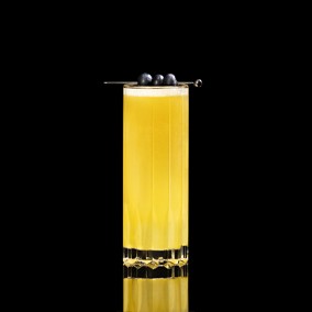 A closeup of a Wings of Passion Fruit drink against a dark background.
