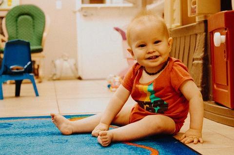 Baby sitting and smiling during New Hope Kids playtime
