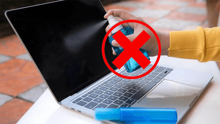 A person cleaning a laptop screen incorrectly with a spray bottle, with a red X symbol indicating a mistake.