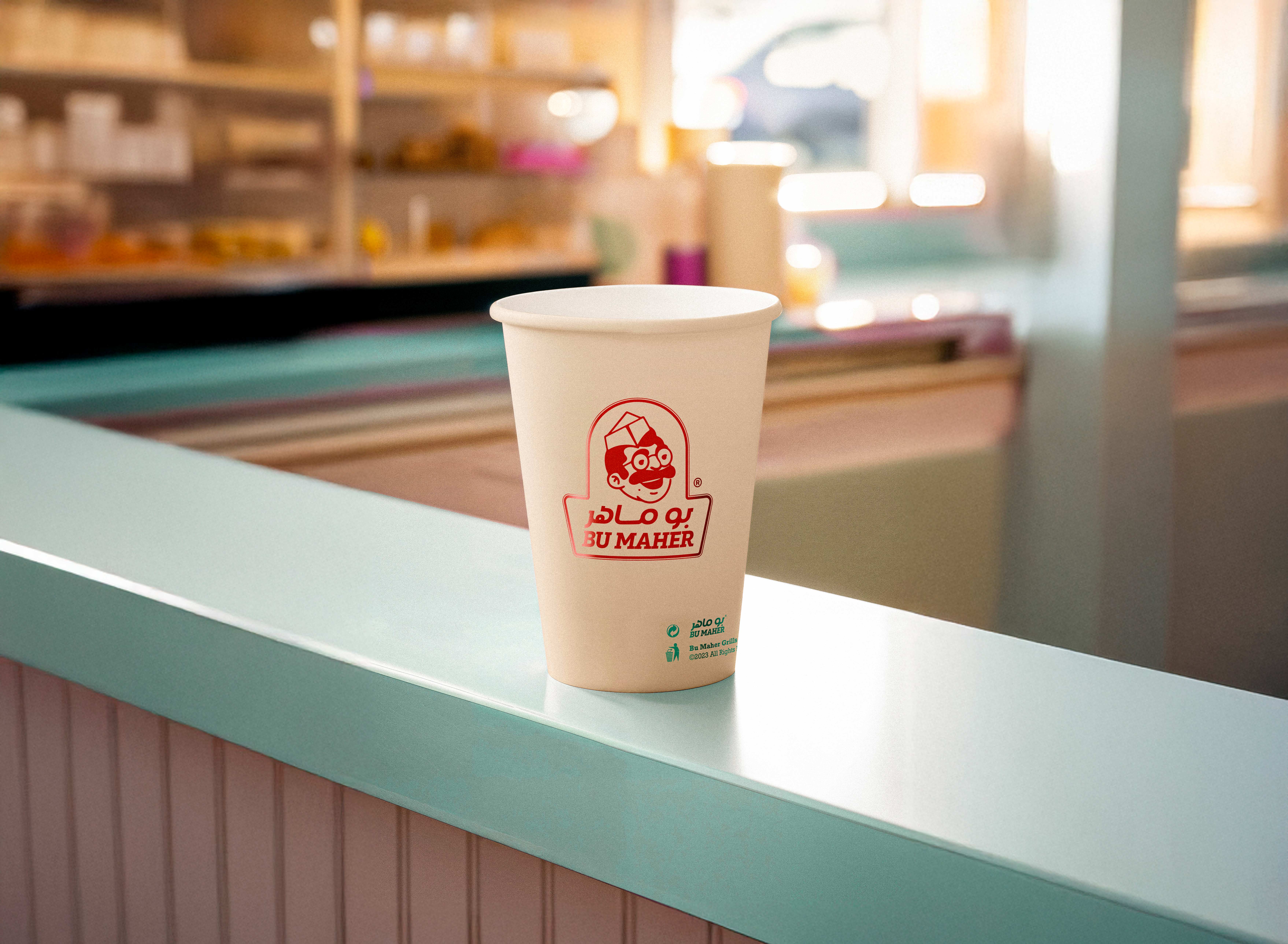 Bu Maher paper cup on a counter, brand strategy and identity by Colada