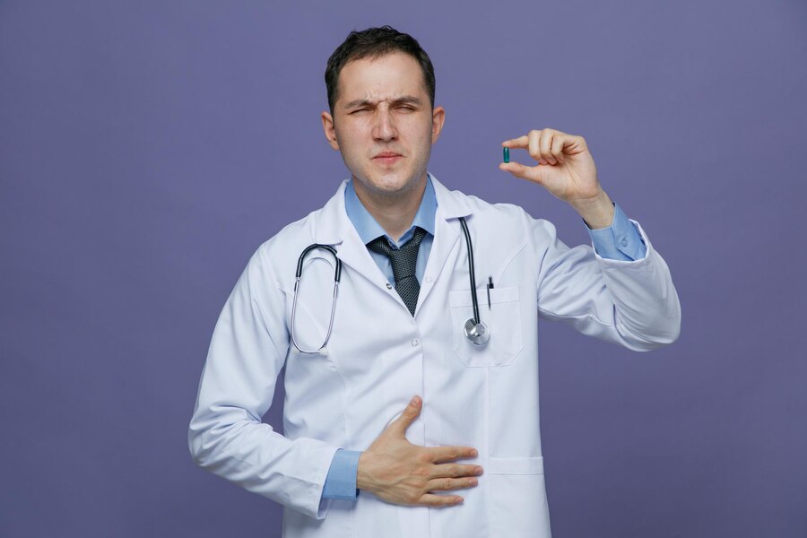 A doctor showing how capsules work on the stomach.