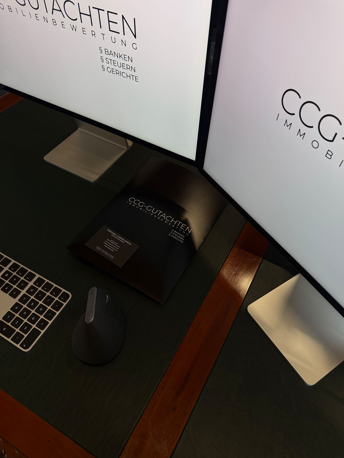 Arbeitsplatz mit zwei Monitoren und Markenmappe von CCG-Gutachten Immobilienbewertung