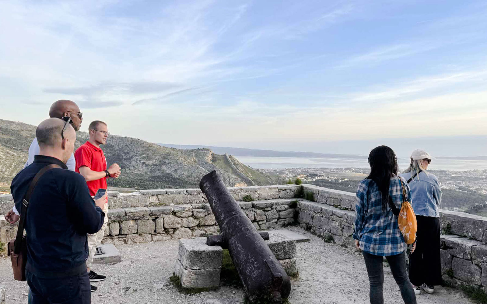 Turisti che osservano Spalato da un antico forte con un cannone, parte del Tour Panoramico in Bus di Spalato.