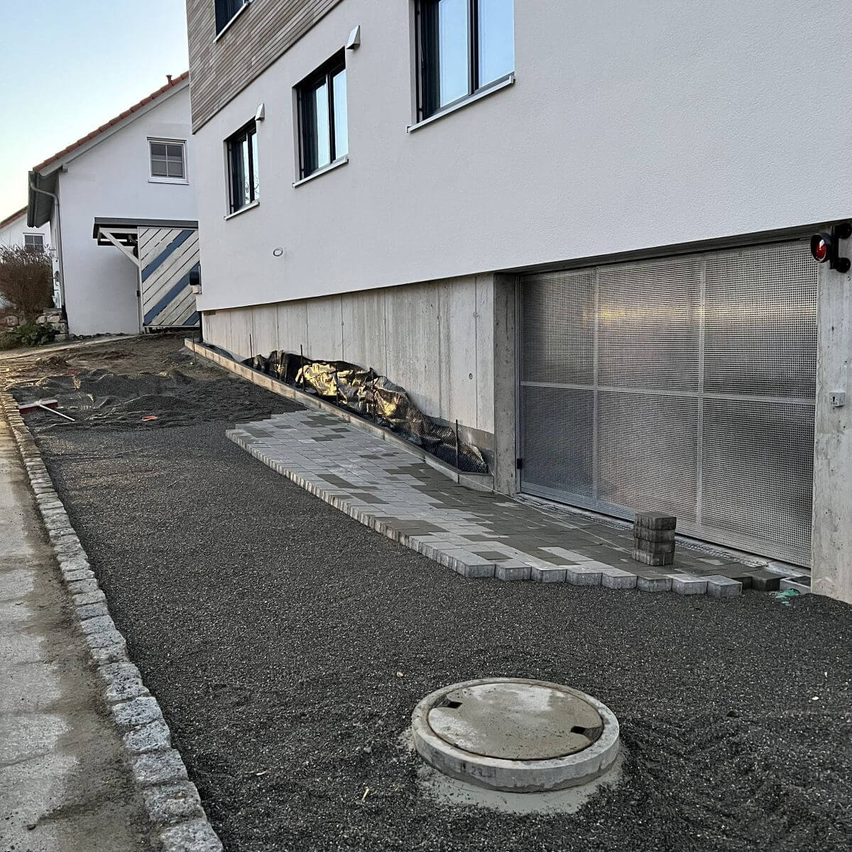 Gartenbau-Baustelle in Baindt: Vorbereitung einer neuen Einfahrt mit Randsteinen und Schotterunterbau durch den Fachbetrieb Klingenstein.