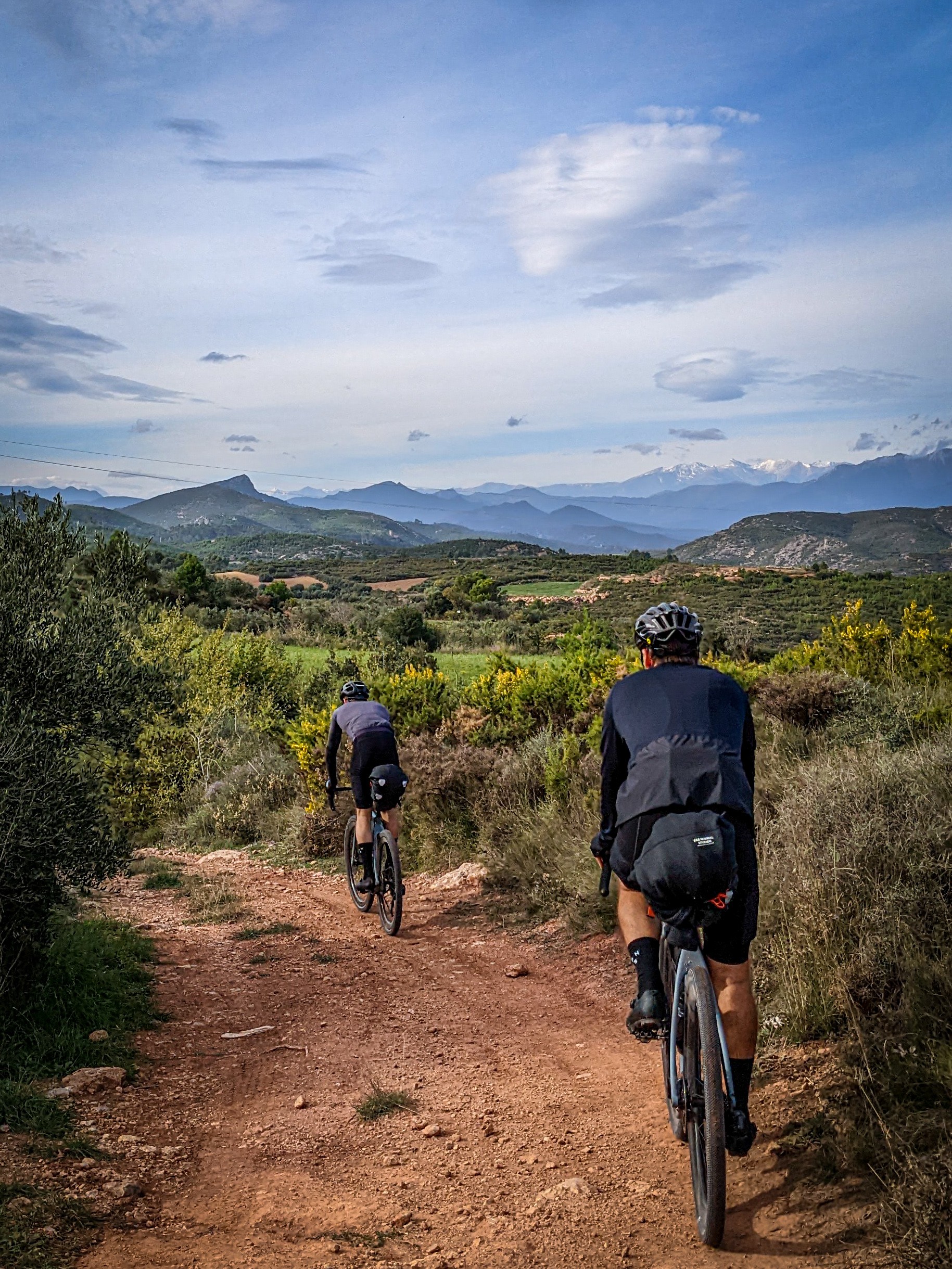 Cyclists riding gravel roads through the hills surrounding Girona.