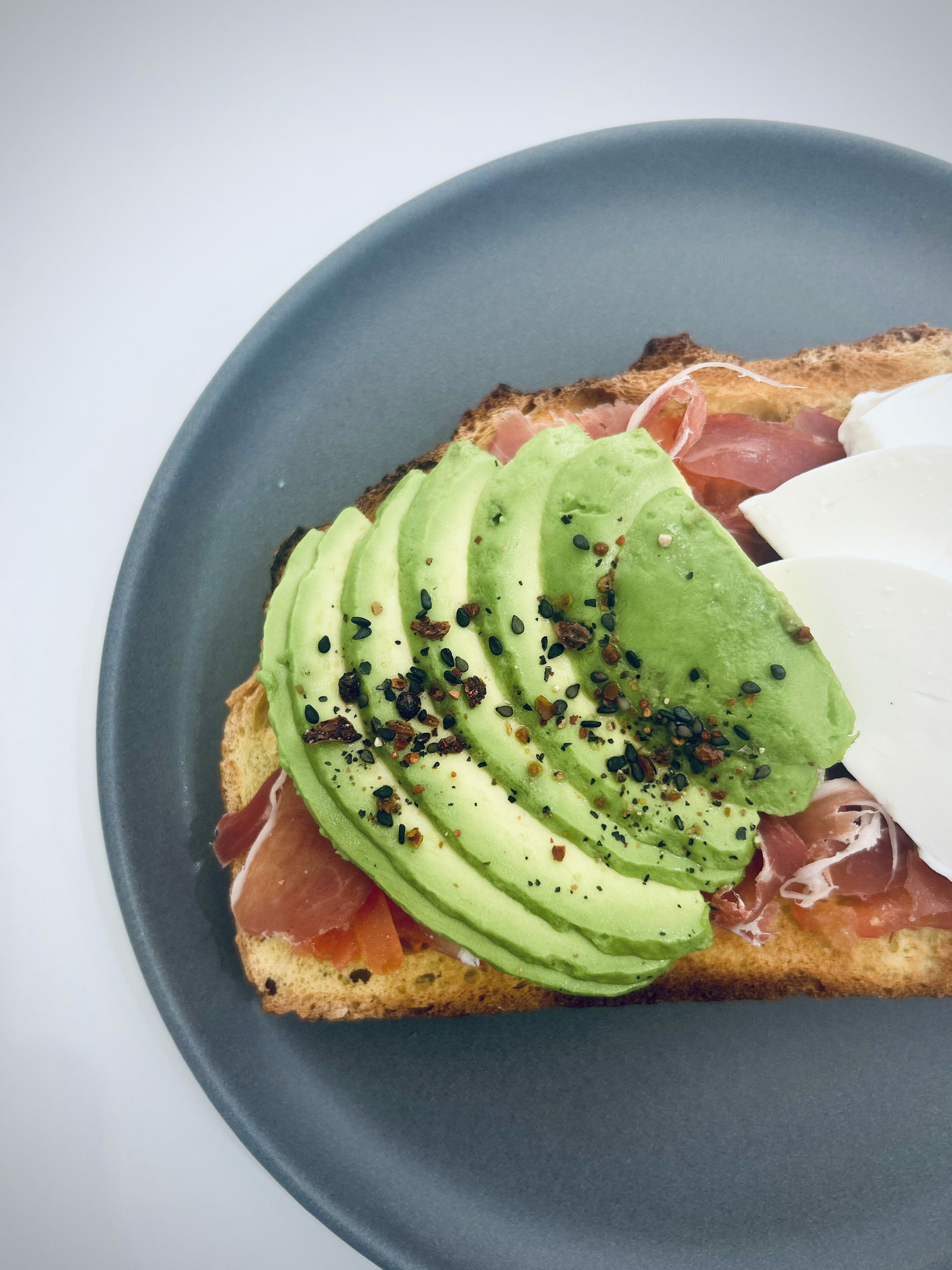 tostada de pan frances artesanal con toppings saludables de aguacate jamon serrano y queso fresco