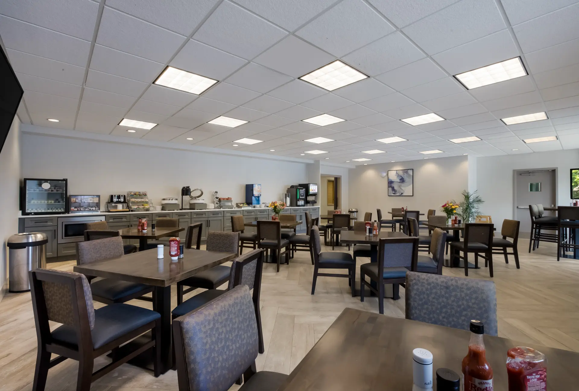Dining area with tables and chairs and a counter with food and beverage service.
