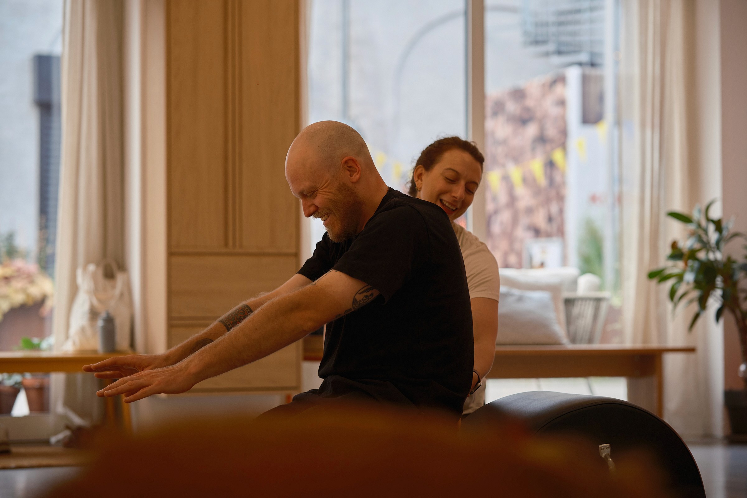 Smilende mand laver pilatesøvelse på en spine corrector