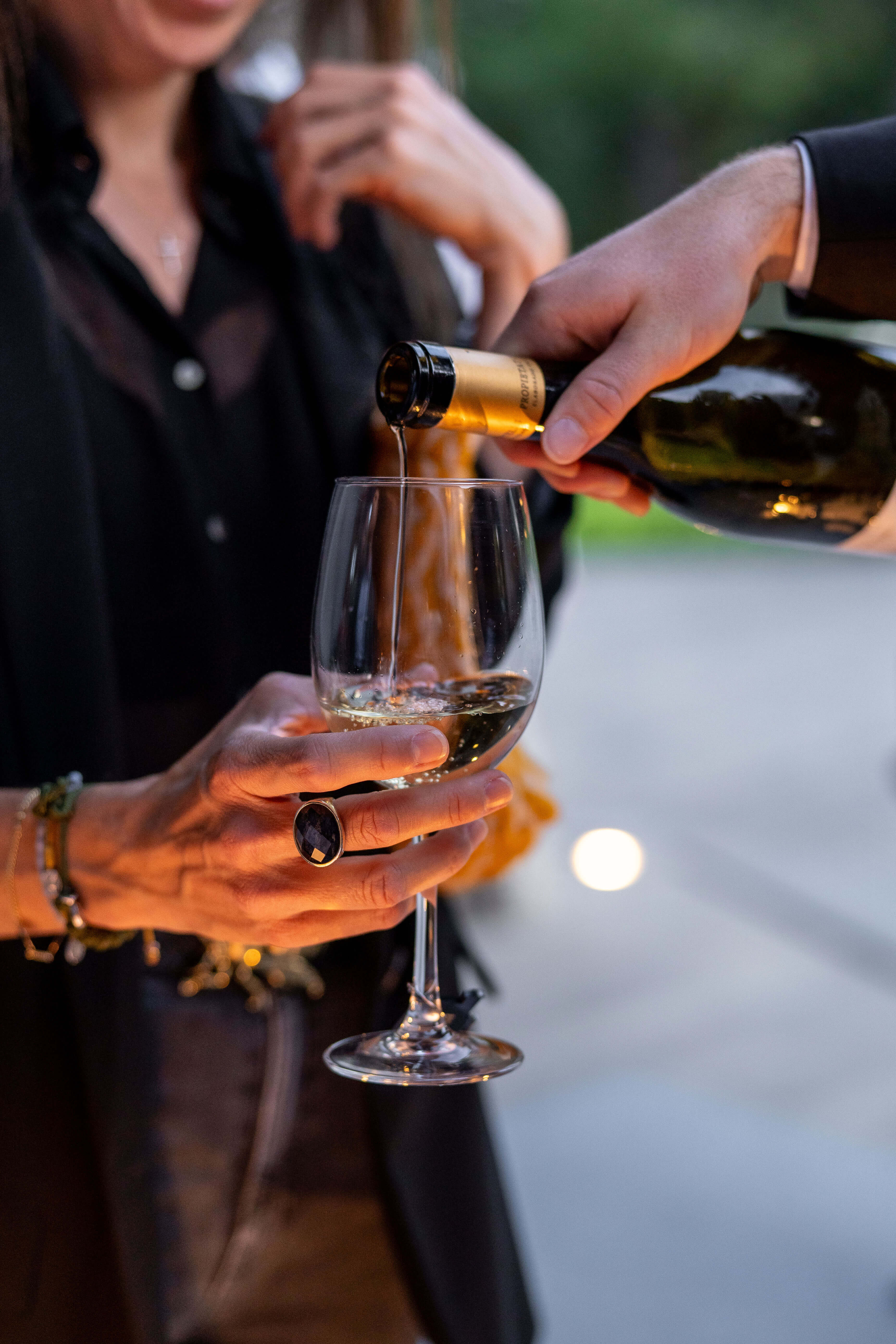 Mano sosteniendo una copa mientras se sirve vino
