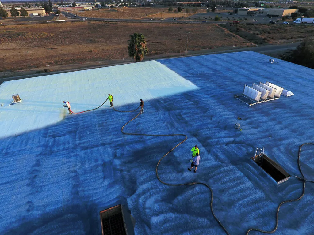 installing blue primer and spray foam roofing system