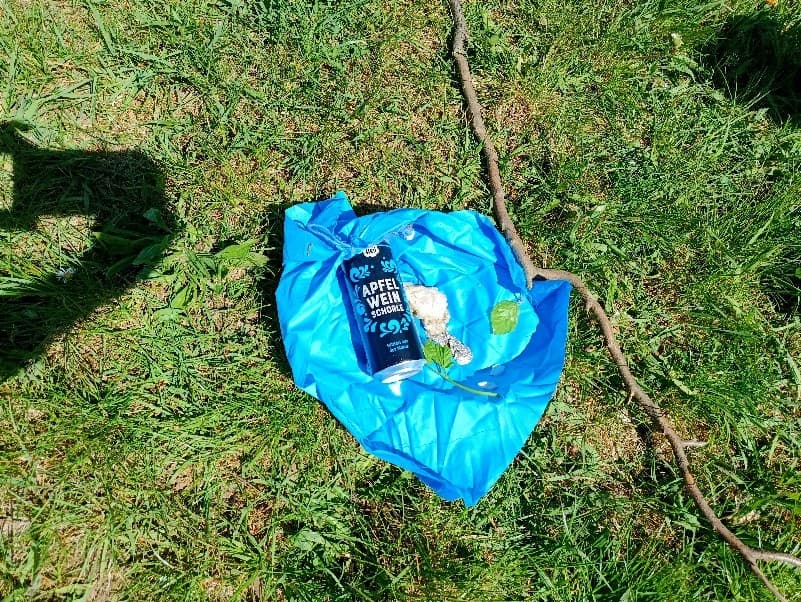 gegenstände auf einem blauen plastik-beutel in einer wiese
