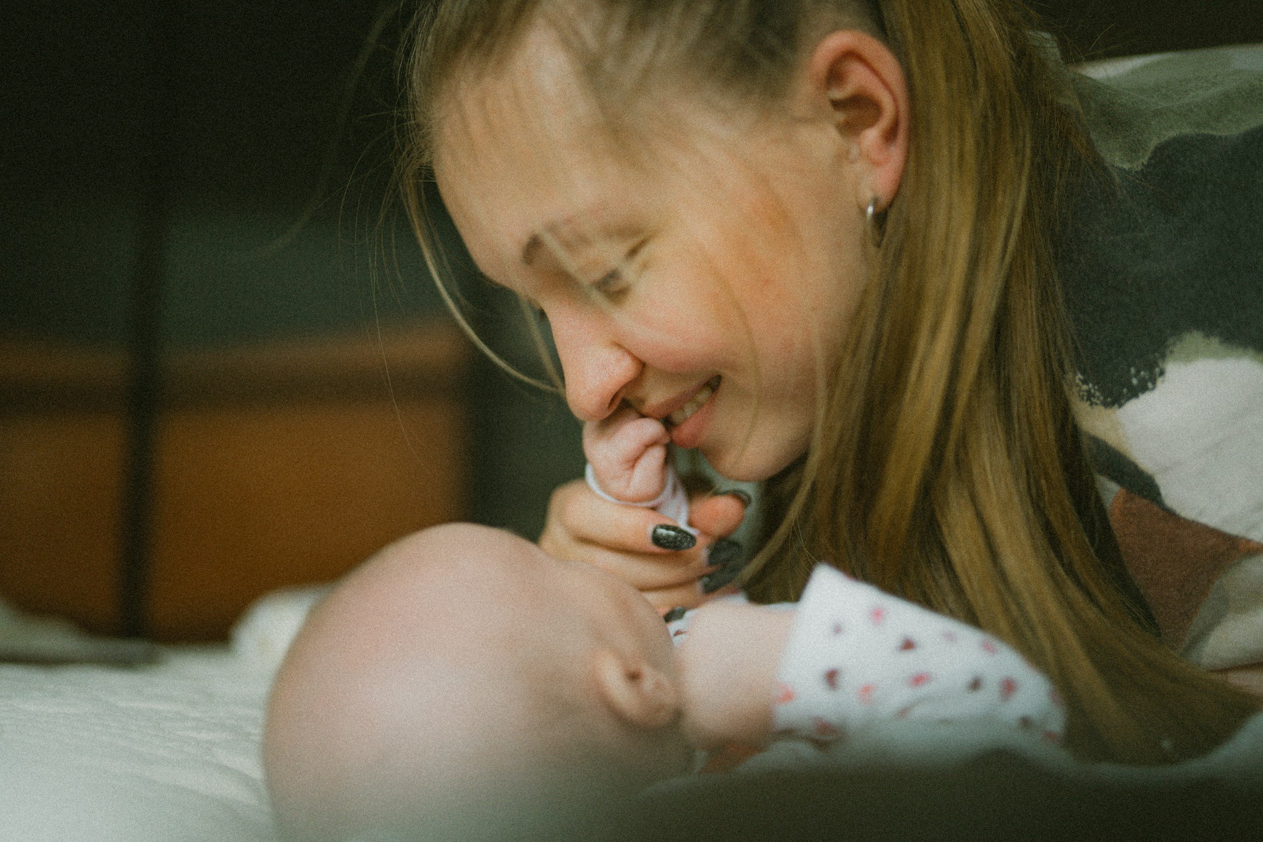 Close-up of a mother smiling tenderly while touching noses with her baby